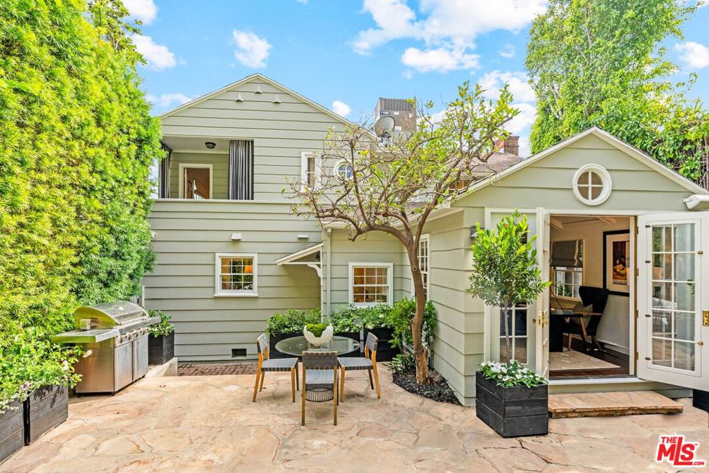 Nestled at the base of Laurel Canyon lies this effortlessly elegant 1937 Traditional-style home which has been respectfully updated for those who desire contemporary comforts but crave a touch of old school glamour. Welcome guests into the graceful foyer and spend the evening making music and sharing stories in front of the wood burning fireplace in the spacious living room. Cook to your heart's delight in the open-spaced chef's kitchen and dining area, complete with a center island with a gorgeous Carrera marble countertop. Ascend the romantic magnesite staircase to the chic primary suite which boasts peek-a-boo city light views, a walk-in closet and marble bathroom. 2 additional bedrooms upstairs share a bathroom with separate tub and shower. At the rear of the home, a versatile room with vaulted ceilings and built-in bookshelves makes for an ideal den, library or inspiring home office. It opens to a sizable flagstone patio with fountains, mature landscape and flower boxes, a firepit and spa, perfect for either evenings of effervescent entertaining or nights spent intimately relaxing in your own enchanted retreat. Only moments from the best restaurants, shops and nightlife of the Sunset Strip and Hollywood, this home is also perfectly poised for quick access to the studios in the Valley.