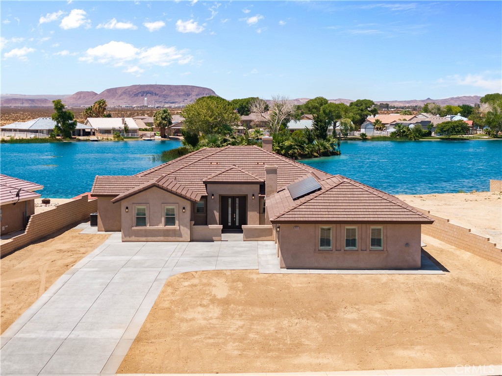 WELCOME TO THIS STUNNING LAKE HOME, IN A PRIVATE AND TRANQUIL COMMUNITY!!
This custom-built home offers 3,151 square feet of luxurious living space on a serene lakefront lot. Perfect for fishing, swimming, relaxing, and enjoying breathtaking views from the comfort of your living room. This home features four spacious bedrooms and 2.5 bathrooms, with top-tier energy-efficient upgrades including: fully paid solar panels, Double-glazed low-energy windows, a Tankless water heater, central air conditioning, R-38 attic insulation, and a Fire sprinkler system.
Step inside to an open floor plan adorned with beautiful ceramic tile flooring and Shutters throughout the house, as well as recessed lighting. The gourmet kitchen features an oversized quartz island and countertops, custom cabinetry with self-closing doors and drawers, a spacious pantry with shelving, a stylish backsplash, and stainless steel appliances.
The luxurious master suite features a large room with a Lake view, plush carpeting, an elegant bath with a separate tub and shower, quartz countertops, and a custom walk-in closet with built-in shelving. Additional highlights include: Upgraded bathrooms with quartz countertops, recessed lighting throughout, a covered back patio with lake views, a Private laundry room with a 220V outlet, and a Spacious 3-car garage with Epoxy flooring, door opener, and remote control. The home is equipped with a surround sound system throughout. And an electric fireplace in the front of the house for family gatherings. Enjoy tranquil lakefront living in a house designed for comfort, efficiency, and style. Don’t miss your chance—schedule a showing today!