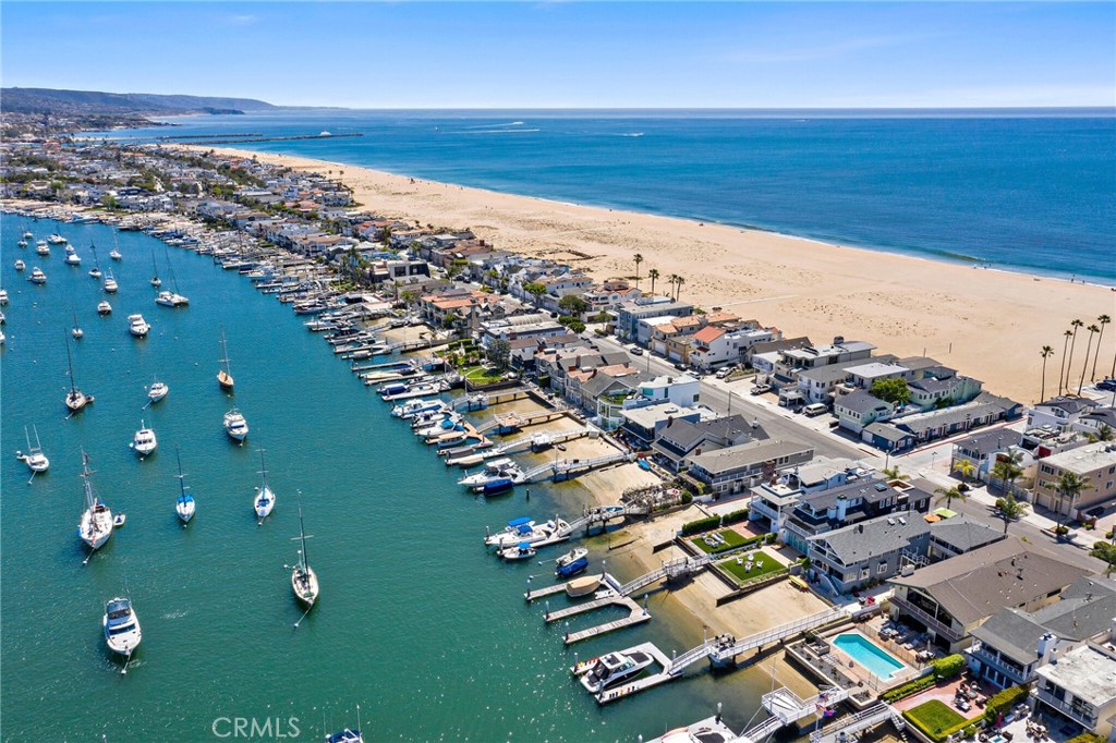 Occupying an enviable position on Newport Harbor, this recently built bayfront masterpiece by acclaimed William Guidero Design and Winkle Custom Homes personifies our iconic destination and the idyllic lifestyle it affords. Meticulously crafted with classic lines and a crisp coastal aesthetic showcasing extraordinary sight lines and abundant light, all delivered in a timeless design language befitting of any discerning buyer. Enjoy ever-changing cinematic views and inspired vignettes from all three floors including the newly refurbished rooftop entertaining deck. Boats gently glide across the shimmering bay, harbor lights give way to postcard-worthy backdrops framed by rolling hills and glittering buildings of Fashion Island as historic Balboa Pavillion anchors the inspired scene. Situated on an exceedingly rare, oversized corner-lot, the home features expansive outdoor space as well as a newly-constructed dock able to accommodate a yacht up to 57ft, in addition to a side-tie. The home itself provides every imaginable amenity with a gorgeous Chef's Kitchen outfitted with best-in-class appliances, and chefs office. The grand owner's suite features a large private balcony, fireplace, spa bath, dual closets and of course views perched above the bay. A library nook, two additional guest rooms both with ensuite baths and separate balcony complete the second floor. The penthouse level is an entertainer's dream; A game and cinema room opens to a large beach-facing deck on one side and the bayfront rooftop terrace on the other. Fully outfitted with an outdoor kitchen, fireplace, and breathtaking views. The finished garage, thoughtfully placed and with soaring ceilings allows for generous storage and potential for a car lift. Top-tier audio, visual, security and lighting have all been appointed throughout. An elevator discreetly accesses all levels of the home. A location seemingly plucked off the map to afford the best of all worlds; A stroll away from the Balboa Village, ferry, beaches, pier, boardwalk, shops, restaurants and more. Unable to be duplicated today due to newer zoning, this opportunity is a resounding one.