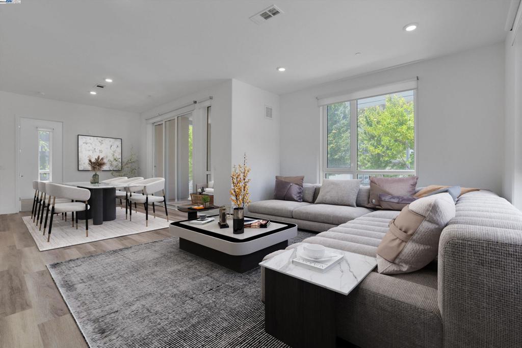 Modern comfort meets prime convenience in this luxurious 3-bed, 2-bath condo located in the heart of Fremont. This spacious ground-floor end unit features an open-concept layout with high ceilings, expansive windows, and abundant natural light throughout. The kitchen showcases sleek cabinetry, modern countertops, and a large island perfect for entertaining. The generously sized primary suite offers a walk-in closet and double vanity, while two additional bedrooms are ideal for family, guests, or a home office. Additional highlights include in-unit laundry, central A/C and heating, and a private patio perfect for relaxing outdoors. This home includes two assigned side-by-side underground parking spaces, complete with an EV charger—a rare and valuable convenience. Enjoy access to resort-style amenities including a pool, fitness center, clubhouse, playgrounds, and more. Conveniently located within walking distance of Warm Springs BART, with easy access to major freeways and tech campuses, offering the perfect blend of modern living and commuter ease.
