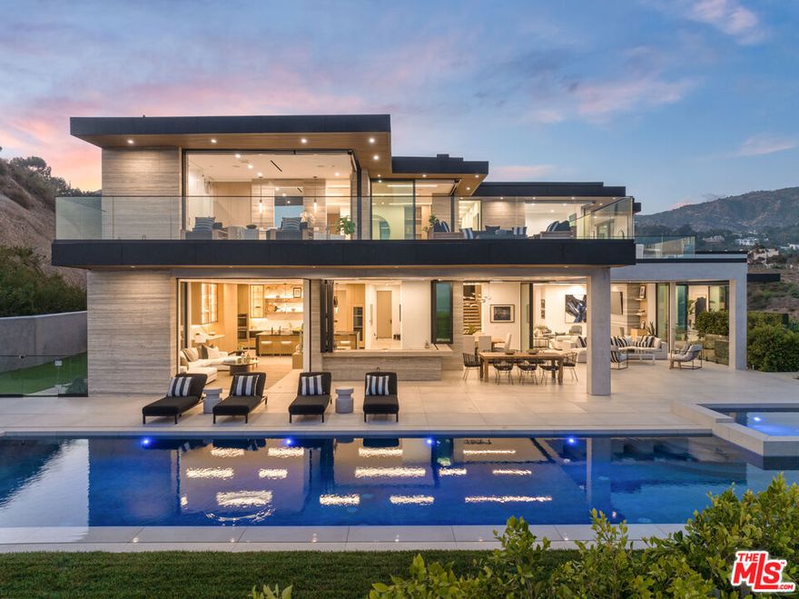 New Construction in Malibu. Located in the private, gated enclave of Malibu Colony Estates, this stunning home offers breathtaking ocean views and contemporary design by renowned architect Douglas W. Burdge, AIA. One of just four homes in this prestigious community, it sits on approximately 1.3 acres with five bedrooms and ten bathrooms. A dramatic pivot entry door, framed by sculptural water features, sets the stage for the seamless indoor-outdoor flow of the home. Expansive glass walls, high ceilings, and premium materials like vein-cut travertine and rare Calcutta Gold stone enhance the elegant design. The grand living room features a striking floor-to-ceiling Blue Bibas marble fireplace, while the gourmet kitchen is equipped with top-of-the-line appliances and custom backlit cabinetry. Designed for effortless entertaining, the outdoor spaces include multiple lounge areas, a covered bar that seats six and an outdoor dining space. The private backyard also features an infinity pool and spa, a firepit with banquet-style seating, and a fenced lawn ideal for pets or play. The main level of the home includes a media area, a full bar with bifold doors to the patio, a spacious dining area, and an impressive office with stunning views. A guest suite with an en-suite bath completes this floor. Upstairs, the primary suite is a private retreat with two en-suite bathrooms, dual walk-in closets, and a wraparound patio with ocean and mountain views. Three additional en-suite bedrooms provide ample space for family and guests. The lower level is designed for entertainment and relaxation, featuring a home theater, game room, gym/bonus room, powder room, additional bathroom, and laundry room. A three-car garage, ample guest parking, and an elevator add to the home's conveniences. Just minutes from Malibu's top beaches and shopping, this estate offers a rare combination of luxury, privacy, and breathtaking surroundings.