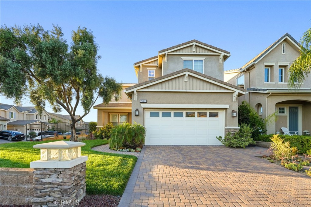 Stunning Contemporary Home in the Guard-Gated Sorrento Community of Porter Ranch. Welcome to this two-story contemporary home, built in 2007 and located in the prestigious guard-gated Sorrento community of Porter Ranch. Offering 2,449 square feet of thoughtfully designed living space, this 3-bedroom, 3-bathroom has what you may be looking for. 24/7 gated neighborhood featuring resort-style amenities, including two pools and spas. From the moment you arrive, you're greeted by mature landscaping, a charming olive tree, and a paved driveway. The modern stucco exterior and attached two-car garage (with an additional tandem space for a third vehicle) add both style and convenience. Inside, the entryway welcomes you with a bright and open layout featuring neutral tile flooring and a dramatic staircase adorned with wood and wrought-iron railings. To the left, a stylish sitting or formal dining area sets the tone for elegant entertaining. Straight ahead, the spacious living room flows effortlessly into the backyard, offering access to a private outdoor retreat, lush lawn, and privacy hedges. The chef’s kitchen is a dream with granite countertops, a large center island with bar seating, top-tier stainless steel appliances including a built-in refrigerator, and abundant cabinetry. The adjoining family room features a cozy fireplace and large windows that fill the space with natural light. Additional features on the first level include a convenient powder room, direct access to attached car garage, and a hallway with built-in coat hooks. Upstairs, you'll find a versatile loft area and all three bedrooms, including a luxurious primary suite with mountain views, plush carpeting, and a spacious sitting area. The en-suite bath is a true sanctuary with dual vanities, a soaking tub, walk-in shower, and an expansive walk-in closet. The two additional bedrooms include ample closet space, with one offering direct access to a shared full bathroom. A separate upstairs laundry room with white cabinetry and a utility sink adds further convenience. Don't miss the opportunity to own this exceptional home in one of Porter Ranch’s most desirable gated communities.