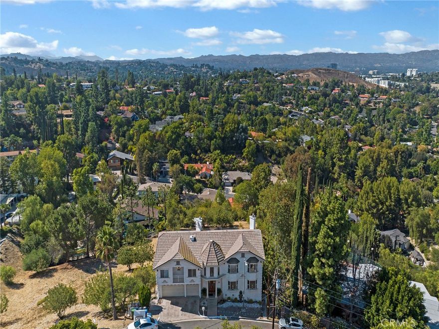 Absolute must-see! Elevated, exceptional Vista de Oro estate with breathtaking 180° panoramic views from virtually every vantage point. Located South of the Boulevard in Woodland Hills’ most desirable enclave. Enjoy an idyllic drive past pride-of-ownership estates leading to nearly 5,000 sq ft of living space on an expansive 22,500+ sq ft mostly flat lot. This 5-bedroom, 5-bath residence offers unique expansion potential for multi-generational living, resort-style entertaining, a luxury family compound, or the future development of multiple ADUs.



A double-door entry opens to a dramatic two-story foyer with a glass-framed staircase. The main level features a cozy reception area, a spacious living room with fireplace and walls of glass framing unobstructed valley and city-light views, an oversized formal dining room with wet bar, and a chef’s kitchen with generous granite counters, stainless steel appliances, and its own scenic balcony. Multiple decks and balconies flow seamlessly for both grand entertaining and everyday living. A symphony of windows, skylights, and glass doors bathes the interiors in natural light.



Upstairs, the private retreat showcases a large primary suite with soaring ceilings, dual balconies, fireplace, walk-in closet, and spa-style bath. Four additional bedrooms with high ceilings and four baths offer flexibility for family or guests. The open loft area can serve as a home office. On the lower levels, discover a full-size family/game room with wet bar, a theater room, ample storage, and a separate suite with its own entrance—ideal for extended family, studio, or creative workspace. An unpermitted ADU w/ two bedrooms and a bath, not included in the official count, further expands the home’s potential for rental or multi-unit living.



Outdoors, the property’s broad, level backyard is a blank canvas—ready for a pool, sport court, garden, or multiple ADUs. Enjoy sweeping sunrise and sunset views while being minutes from Calabasas, Ventura Blvd., Warner Center, The Village, Westfield Topanga, fine dining, top schools, and the 101 Freeway to the Westside. A not-to-be-missed opportunity to reimagine a substantial Vista de Oro estate. Whether customizing to your taste, creating multi-residences, or enjoying as is, the scale, lot size, and views make this home a truly spectacular offering. Property sold as-is in its present condition, subject to buyers' inspections. Motivated long-term owners, do call us today for your private showing!