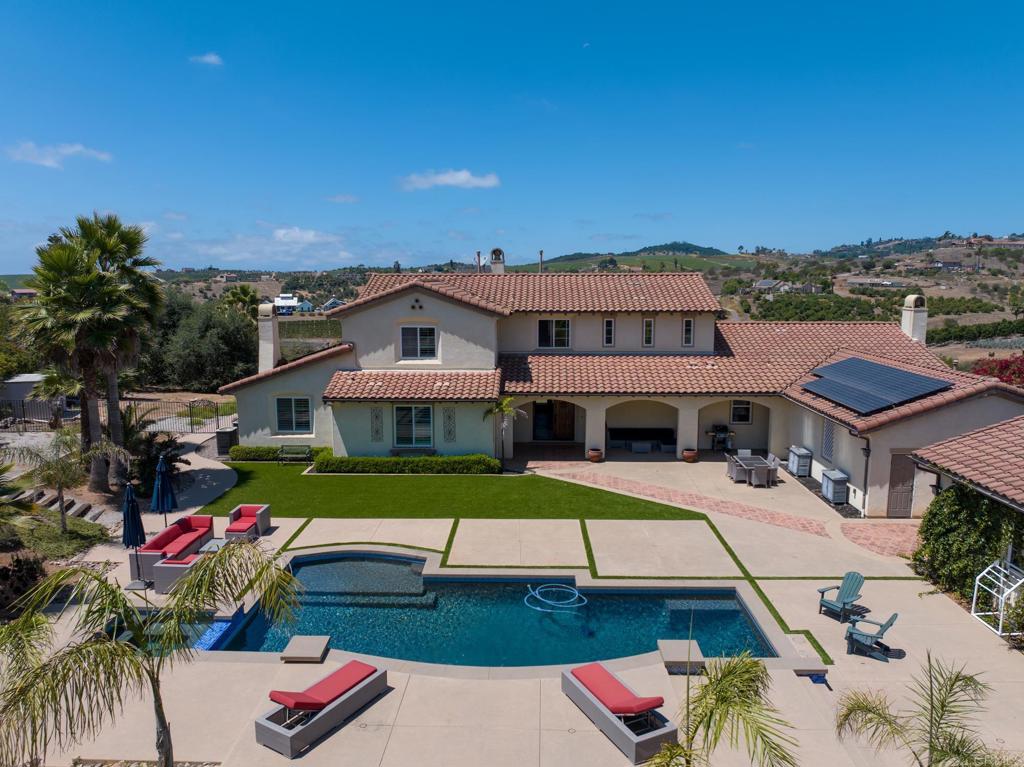 Welcome to your private oasis nestled in the rolling hills of coveted Bonsall, CA. As you arrive through the private gates, you're welcomed into a resort-style retreat featuring a saltwater pebble tech pool and spa with baja shelf, multi-level patios, soothing fountain accents, and ample space for lounging or entertaining in peaceful privacy. Set on 2.01 acres at the end of a quiet cul-de-sac, this exquisite Mediterranean estate offers rare seclusion, coastal breezes, and breathtaking views. Boasting 4 spacious bedrooms and 3.5 bathrooms, this thoughtfully designed home showcases soaring ceilings in the formal living and dining rooms, an abundance of natural light, and three cozy fireplaces. The expansive primary suite is a true retreat with a spa-inspired ensuite, with a large custom shower and separate jetted tub, and a large walk-in closet. The gourmet kitchen features a generous island, dual ovens, and seamless access to outdoor living spaces designed to capture brilliant Bonsall sunsets. Additional highlights include a versatile second-floor loft adjacent to the 4th bedroom and full bath, dual-zoned HVAC, solar system, a 4-car garage, and a large driveway with RV parking. The fenced front yard adds charm and function, while the acreage offers potential to add a shop or ADU. With sunrise views from the front porch and spectacular sunsets from the back patio, this is a rare opportunity to own a unique slice of Southern California paradise.