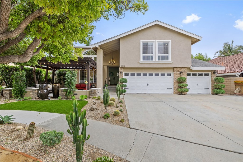 Welcome to your dream home! This beautiful remodeled home offers a combination of charm, functionality, and style. Nestled in a quiet cul-de-sac in the sought after area of South Coast Metro in Santa Ana. From the moment you arrive, you’re greeted by stunning curb appeal — complete with manicured desert landscaping, elegant stonework, and a cozy patio area with relaxing water fountains. Step inside to a bright and spacious main living area, where soaring ceilings and abundant natural light create an open, airy atmosphere. A striking floor-to-ceiling stacked stone fireplace anchors the room, complemented by an oversized chandelier and warm wood accents that elevate the space. The open layout flows effortlessly into the dining area and kitchen. Just off the main living area, you'll find a main-level bedroom and full bathroom, ideal for guests. The kitchen is a chef’s dream, with shaker cabinetry, quartz countertops, stainless steel appliances and a window overlooking the backyard pool—letting in natural light and offering a serene. The family room provides extra space for relaxation & entertainment. The custom shelving and bar area enhance this space, making it perfect for hosting guests or enjoying family time. Adjacent to the family room is a guest bathroom, beautifully remodeled with a convenient walk-in shower. As you make your way up to the second level, you will find the generously sized primary bedroom with high vaulted ceilings, an abundance of natural light, his and hers closets with tall mirror doors, a cozy sitting area-perfect for reading or relaxing, and an ensuite bathroom. The other two bedrooms and guest bathroom are also in the second level. The bathroom features a luxurious, modern design with a spa-like feel. The sleek, white freestanding bathtub is a central piece, surrounded by an all around elegant design. Bonus feature- This home also includes a private attached unit with its own entrance! Tucked along the side of the home, this stylish and secluded space includes a living area, kitchen, full bathroom, and bedroom — perfect for extended family, guests, or rental income potential. The private pool is the central feature, surrounded by lush greenery and palm trees that create a peaceful and tropical atmosphere, a resort-like feel. This home is absolutely stunning and unique! In prime location just minutes from South Coast Plaza, schools, parks and much more. Schedule your private showing before it's gone!