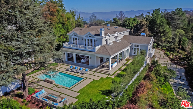 Welcome to the Happily Ever After Home. Cape Cod infused with California glamour, this brand new constructed private, gated estate combines old-world grandeur and elegance, with luxurious modern amenities. Designed for entertaining, this timeless home is a standout combination of the classic and the contemporary, achieving the balance of tradition with modern impact. Marvel at the seamless merging of indoors and outdoors, along the luxurious beauty of the sun-filled main living area, which leads to a stunning outdoor space, complete with beautiful vignettes surrounded by exquisite water features, gleaming salt water pool and breathtaking views set in the most desirable location of Beverly Hills. With up to 16 ft high ceilings, elaborate wainscoting, custom wood work, lux stones, wine gallery, media room, gym, yoga deck, stately en-suite bedrooms with private balcony's, the best of crisp east coast beach style meets west coast sophistication in this unique, lushly-landscaped paradise.