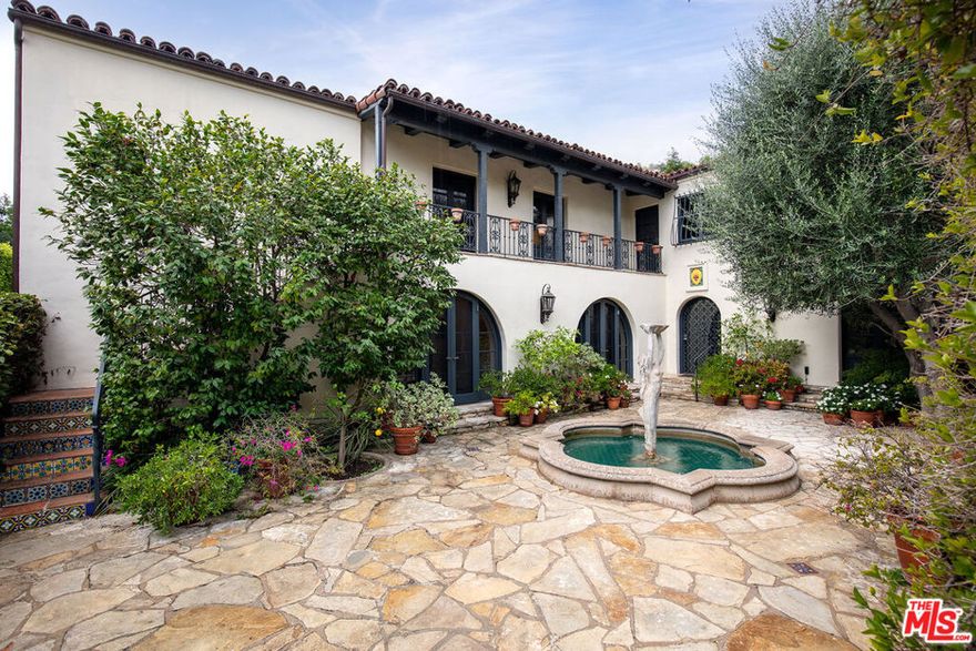 Walled and gated 1926 Spanish on extremely desirable Walden Drive in prime west end Beverly Hills flats. Recently refreshed and staged, and filled with romance and charm at every turn, this classic home has been tastefully remodeled while preserving the integrity of the original early California Spanish architecture. Much-admired street presence, private courtyard entry with original sculptural fountain, exceptional detailing and gorgeous gardens throughout. All the signature elements of the period can be found here including thick plaster walls, arched openings, French doors, beamed ceilings, hardwood & Saltillo tiled floors and original hardware, fixtures, ironwork, stained glass and paneled doors. Grand scale living room with exquisite wood beamed ceiling and ornate hearth, beautifully proportioned formal dining room, remodeled kitchen with adjacent breakfast room, inviting library/den and large family room - all of which open through arched French doors to courtyard, trellis-covered patios and lush yard. Fabulous primary suite with sitting area, generous bath and fitted closet. Two additional bedrooms upstairs, each with bath; and potential fourth bedroom downstairs. Other amenities include an oversized, direct access private garage and elevator. A very special offering in the best Beverly Hills flats locale.