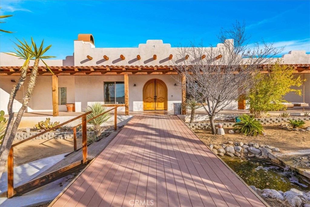 Welcome to your dream home in Joshua Tree, where desert living meets Santa Fe style! This beautiful house is perfectly located near the breathtaking Joshua Tree National Park, offering you a serene and picturesque environment to call home. With 5 bedrooms and 3 baths spread across 3120 sq. ft. of living space, this spacious oasis provides you with plenty of room for both relaxation and entertainment.
Situated on 2.5 acres of desert land, this house ensures your privacy and tranquility. The fully fenced and secured property features stucco walls, providing a sense of safety and peace of mind. As you approach the house through the beautiful double door entry, you are greeted with an open floorplan that invites you to explore and unwind.
The kitchen is a chef's delight, boasting granite counters, a kitchen island, and stainless steel appliances that elevate both its style and functionality. Enjoy the convenience of a wine cooler, perfect for entertaining guests or indulging in a glass of your favorite vintage. The bathrooms continue the sleek and stylish theme, featuring granite counters, a soaking tub, a vanity area, a walk-in shower, and a shower/tub combo.
Step outside into the enchanting exterior space, where you'll find multiple seating areas that offer endless opportunities for relaxation and outdoor gatherings. Lounge on the wooden deck, fire up the outdoor BBQ, or sway in the gentle breeze on the hammocks while taking in the stunning views of the desert landscape.
A true oasis wouldn't be complete without an in-ground pool and spa, providing the ultimate spot for cooling off during the warm desert days and unwinding under the starlit skies of Joshua Tree at night while on the roof deck above the garage.
The meticulous landscaping surrounding the property includes Joshua trees, cacti, cholla, and palm trees throughout, enhancing the beauty and authenticity of this Santa Fe-style home. Immerse yourself in the awe-inspiring vistas that stretch out before you, showcasing the raw beauty of the desert landscape.
In this remarkable house, you will find a harmonious blend of comfort, style, and natural splendor. Your new home in Joshua Tree offers a haven where you can escape from the hustle and bustle of everyday life and embrace the unique charm of this remarkable desert sanctuary.