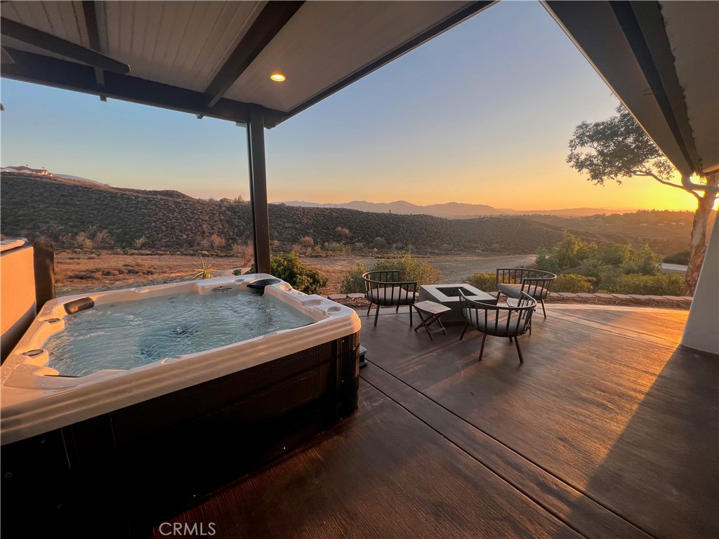 Incredible investment and lifestyle opportunity in the heart of Temecula Wine Country! Welcome to 35251 Calle Campo, a fully turnkey, 5-bedroom, 2.5-bath hilltop estate on 4.5 acres with panoramic valley views, luxurious indoor/outdoor living, and verifiable short-term rental income. This furnished, move-in-ready home is less than 5 minutes from award-winning wineries and just 10 minutes to Old Town Temecula, offering privacy without sacrificing convenience.
Inside, you'll find a sprawling open-concept layout with large sliding windows framing the view, a chef’s kitchen featuring dual ovens, indoor grill, massive walk-in pantry, and full dining area. The great room includes a pool table, 75” TV, soundbar, reclining sectional, and ambient fireplace. The expansive primary suite features a spa-style bathroom with soaking tub, dual rain showers, and dual sinks. Four additional bedrooms offer flexible sleeping arrangements for guests or extended family.
Outside, enjoy a built-in BBQ kitchen, three fire pits, ping pong, and a six-person spa, covered patios with lighting and fans. A graded pad with 100 AMP sub-panel, water, and septic hookups is ready for an ADU, trailer, or tiny homes. A trailer currently on-site is available for separate purchase. A 200 AMP main panel supports additional development. No HOA, zoned Rural Residential. This is a rare chance to own a high-producing property with expansion potential in one of Southern California’s most sought-after destinations.