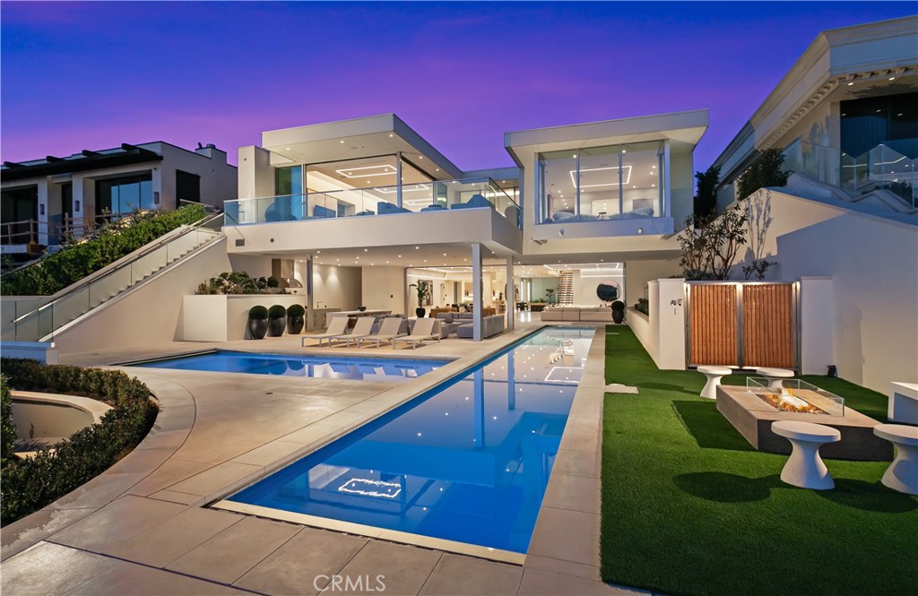 1119 Dolphin Terrace, a generational trophy property showcasing exceptional modern design and architectural excellence located in the heart of Corona Del Mar's coveted Irvine Terrace community. This meticulously crafted estate, taking six years to reach completion, spans approximately 10,200 sqft of pure luxury on a uniquely deep and expansive lot. This remarkable property boasts 5 bedrooms, including 2 primary bedrooms, and 8 baths, offering unparalleled comfort and sophistication. The interiors feature massive scale and soaring ceiling heights, creating a sense of grandeur that defines Southern California coastal living at its finest. Entertain with ease in the expansive living spaces, highlighted by a media wall with a jaw-dropping 219" LCD TV wall, a well-equipped bar + glass cellar, and two kitchens for culinary enthusiasts. Motorized pocket doors seamlessly blend indoor and outdoor living, leading to a spectacular 65' lap pool that invites you to relax and unwind while enjoying breathtaking ocean, jetty, Balboa, and coastline views. For those who prioritize health and wellness, the property includes a spacious wellness center offering full-size gym, sauna, steam room, and meditation area, ensuring a holistic approach to your total well-being. The attention to detail is evident throughout, making this estate one of the most captivating and exciting properties to ever be publicly offered for sale in Corona Del Mar.  Additional features enhance the allure of 1119 Dolphin Terrace, such as its proximity to the Newport Beach Country Club and Fashion Island, placing world-class amenities at your doorstep. Enjoy the convenience of walking to Balboa Island and relish the central location within Newport Beach, providing easy access to the best that Southern California has to offer. This is not just a residence; it's a lifestyle statement, a testament to luxury living in one of the most desirable locations on the West Coast. Seize the opportunity to own a landmark property that transcends the ordinary, a true embodiment of Southern California's finest. Welcome home to 1119 Dolphin Terrace, where every detail reflects a commitment to unparalleled quality and refinement.