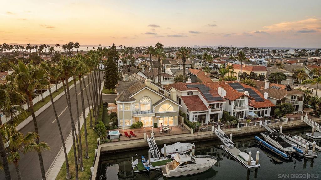 Oversized corner-lot bayfront estate in the coveted Coronado Cays, offering over 4,000 sq. ft. of refined coastal living on a 6,067 sq. ft. parcel with a private dock fit for water toys and an up to 60 ft. yacht. Five bedrooms and 4.5 baths are framed by doubleheight ceilings, travertine floors, and walls of glass that capture unobstructed channel views. An updated kitchen with pro appliances anchors open-concept living and dining zones that flow seamlessly to expansive bay-view terraces—ideal for sunset dinners or cocktail soirées. Lifestyle amenities include hot tub, sauna, full solar, three-car garage, and ground-level guest suite for multi-generational ease. Built in 1989 and meticulously updated, the residence delivers effortless, low-maintenance ownership—designed for maximum enjoyment with minimal upkeep. From your dock, reach Downtown San Diego in minutes; by car or water-taxi you’re under ten minutes to Silver Strand Beach and the iconic Hotel del Coronado.This is Southern California waterfront living at its most effortless and exclusive.