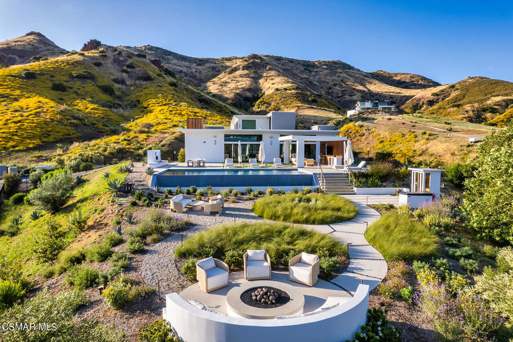 The ULTIMATE contemporary masterpiece estate! Set behind private gates within a small gated community of 11 properties is this one of a kind showplace! With a true premier location in Lobo Canyon, this custom property sits on nearly 9 acres with explosive panoramic views! RECENT renovations include an all new wine wall, wet bar and much more! The incredible open concept floor plan is graced with a MAIN LEVEL primary suite plus one additional en-suite bedroom. stepping up an awesome floating staircase you will find two additional bedrooms and a tremendous bonus/theater room. The resort quality grounds are second to none! There is a 45 foot infinity pool and spa, outdoor living room, barbecue center plus a new fireplace, added firepit and an abundance of professional landscape. Other amenities include multiple Fleetwood pocket doors, 10.5 inch wide plank French oak floors, 12 foot ceilings and one of the most beautiful center island kitchens you will see. This emotional home was designed and built using only the very finest finishes. The opportunities are endless!