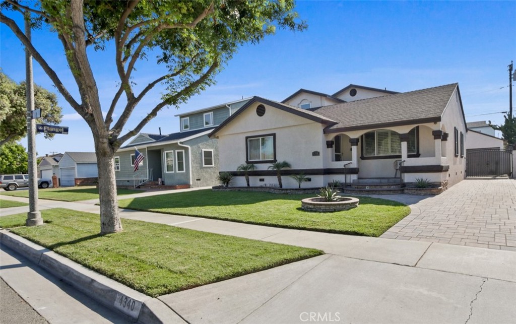 Nestled on a peaceful, tree-lined street, this beautifully updated 5-bedroom, 3-bath home offers comfort, style, and space in the sought-after Lakewood Mutuals neighborhood. Step inside to find new laminate flooring, fresh interior and exterior paint, smooth ceilings, and custom wood shutters that add timeless charm. The open layout features a welcoming living room, a large dining area, and a bright kitchen with white cabinetry, new quartz countertops & stainless steel appliances, and a walk-in pantry. The main level includes three bedrooms and two full baths, including a spacious primary suite with three closets (one walk-in) and a spa-like bath with dual sinks, walk-in shower, and jetted tub. Upstairs, two additional bedrooms and a full bath with walk-in shower provide flexible living space. The backyard is a private oasis with pavers that match seamlessly with the driveway making an expansive area that is perfect for entertaining day or night with ambient lighting, turf play area, and relaxing swim spa. Additional features include central heat and A/C, indoor laundry, and parking for up to 6 cars with a detached 2-car garage and long driveway. Close to Lakewood Country Club, Bixby Knolls, and Long Beach Exchange (LBX), this home offers both tranquility and prime access to shopping, dining, and entertainment.