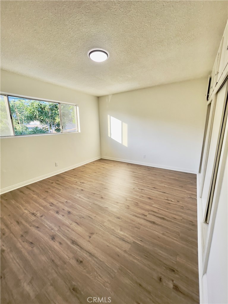This charming second-floor unit is located in a gated apartment complex and features fresh paint, laminated wood flooring, and two spacious bedrooms with one full bathroom. The kitchen offers granite countertops and ample cabinet space. Enjoy the convenience of an on-site laundry room, a window A/C unit in the living room, a wall unit heater, and one assigned parking space. Water and trash are included in the rent. Conveniently located near parks, schools, and shopping.