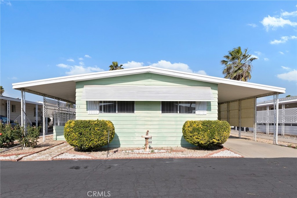 Spacious 2 bedroom 2 bath manufactured home in Eden Roc North 55+ senior mobile home park. Open concept living room/dining room has light paneling, ceiling fans, and china hutch. Kitchen has electric cook top, double oven, and dishwasher. Primary bedroom has 2 closets, large dressing area with seated vanity, mirrored wardrobe, and built-in cabinets. Guest bedroom has built-ins and ceiling fan. Inside laundry. Security front and side screen doors. Huge covered front porch deck and lovely fruit tree. Needs a little TLC, but the dishwasher, water heater, and Roof were all replaced approx 2 years ago. Definitely worth a look!