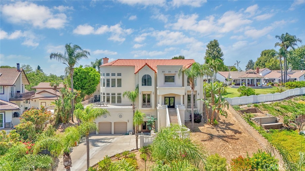 Tucked away in quiet cul-de-sac in a gated community, this exceptional custom estate offers the ultimate private sanctuary in the heart of Yorba Linda. Situated on over half an acre, the home spans approximately 6,900 square feet and features 5 bedrooms, 6 bathrooms, and a rare 9+ car garage, ideal for car collectors, hobbyists, or multi-generational living. Thoughtfully designed, the home includes a spacious primary suite, four generously sized secondary bedrooms, and a separate private studio guest quarters with its own kitchen, bathroom, and elevator access to the main home. The expansive family room opens to a large deck with hillside and city light views, while the elegant formal dining room and fireplace create an inviting atmosphere for entertaining. Outside, the backyard features a pool, spa, 2 firepits, a large covered patio, and a built-in BBQ island, perfect for dining al fresco. A private elevator adds convenience throughout the home. Located within the award-winning Placentia-Yorba Linda School District and zoned for Glenview Elementary, Bernardo Yorba Middle, and Esperanza High School, this peaceful hideaway blends luxury, space, and flexibility in one extraordinary offering.