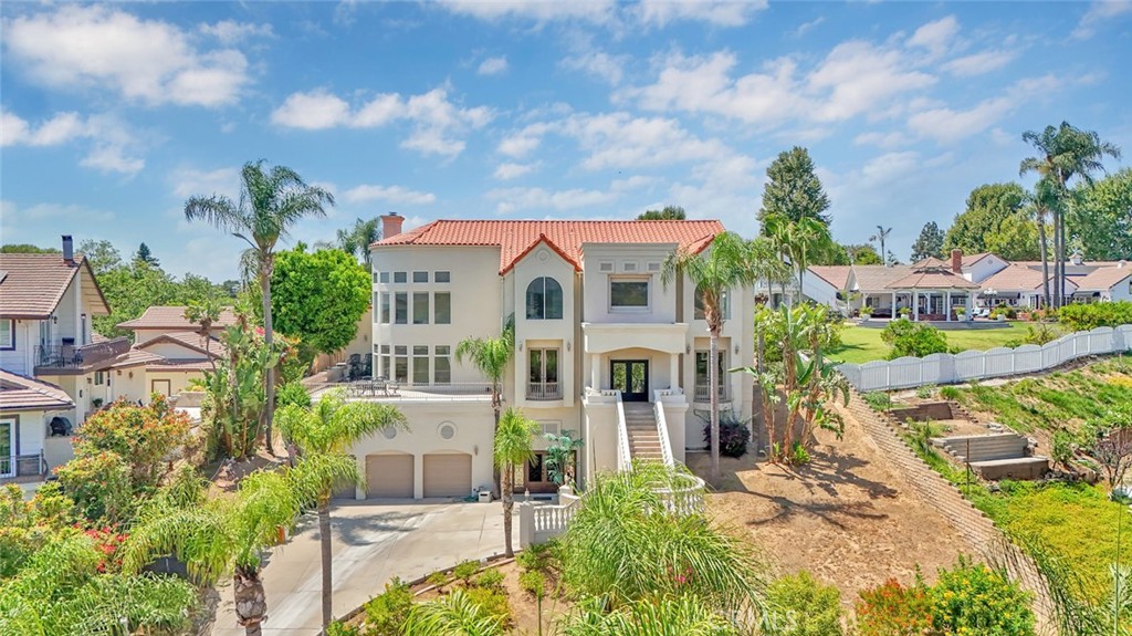 Tucked away in quiet cul-de-sac in a gated community, this exceptional custom estate offers the ultimate private sanctuary in the heart of Yorba Linda. Situated on over half an acre, the home spans approximately 6,900 square feet and features 5 bedrooms, 6 bathrooms, and a rare 9+ car garage, ideal for car collectors, hobbyists, or multi-generational living. Thoughtfully designed, the home includes a spacious primary suite, four generously sized secondary bedrooms, and a separate private studio guest quarters with its own kitchen, bathroom, and elevator access to the main home. The expansive family room opens to a large deck with hillside and city light views, while the elegant formal dining room and fireplace create an inviting atmosphere for entertaining. Outside, the backyard features a pool, spa, 2 firepits, a large covered patio, and a built-in BBQ island, perfect for dining al fresco. A private elevator adds convenience throughout the home. Located within the award-winning Placentia-Yorba Linda School District and zoned for Glenview Elementary, Bernardo Yorba Middle, and Esperanza High School, this peaceful hideaway blends luxury, space, and flexibility in one extraordinary offering.
