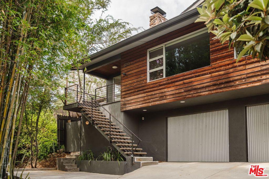 Welcome to 2213 Vestal Avenue, a charming mid-century modern gem nestled in the heart of Elysian Heights. This delightful home, built in 1967, offers 1,384 square feet of inviting living space, perfectly designed for comfort and style. Step into a bright living area where natural light dances around a decorative lava stone fireplace, creating a warm and welcoming atmosphere. The open kitchen, updated with elegant Heath Ceramics tiles, is ideal for culinary adventures and entertaining guests.This home features two spacious bedrooms and two well-appointed bathrooms, making it a perfect sanctuary for relaxation. The additional den (previously a third bedroom, and still a 3b 2b on title) has custom Fleetwood pocket doors that open into an inviting terraced yard boasting 2 dining areas, 2 fire pits, and gorgeous views. The lower level includes 2 Garage spaces and ample driveway parking for any guests or visitors. Walkable to local favorites like Valerie, Lady Byrd, Bacetti Trattoria, Cookbook, and more. Come see what prime Echo Park living is all about.