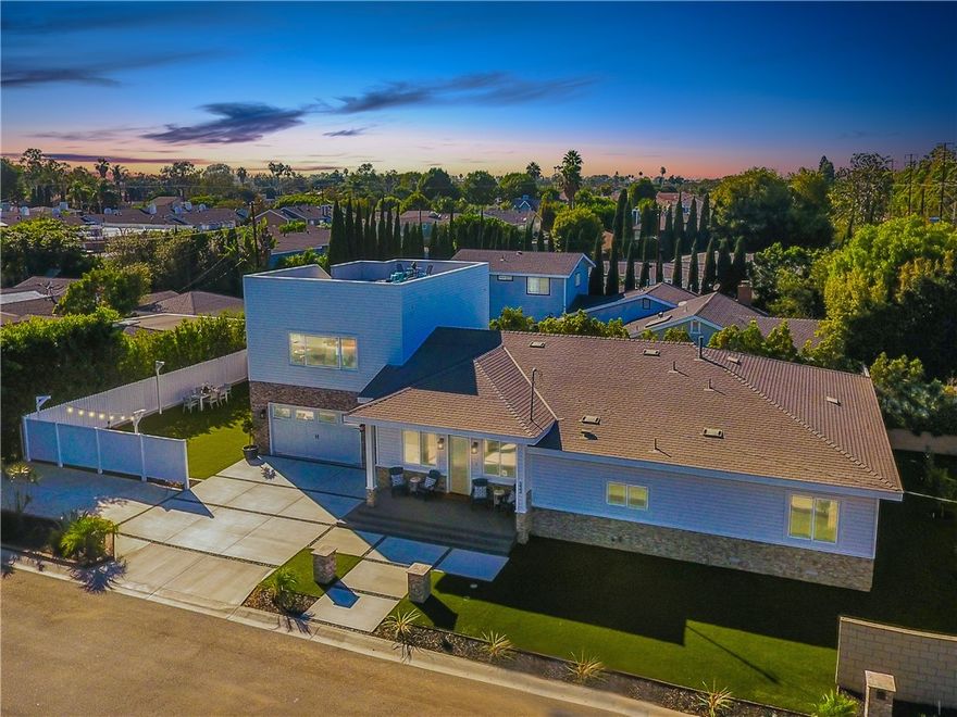 Located on a spacious corner lot in Eastside Costa Mesa, this exceptionally maintained home was built in 2019 and still feels fresh, stylish, and thoughtfully designed. The layout offers a true single-level living experience with all four bedrooms and three bathrooms on the main floor, complemented by ten-foot ceilings, wide-plank wood floors, and eight-foot interior doors throughout. The open-concept kitchen features a tumbled Carrara marble backsplash, walk-in pantry, KitchenAid Professional Series appliances, built-in wine fridge, and custom shelving. The primary suite is a true retreat, offering two oversized walk-in closets and a spa-inspired bathroom with marble floors, a Victoria and Albert soaking tub, and a full-length LED mirror. Above the garage, a generous 690 square foot bonus suite with its own entrance, bathroom, and dedicated air conditioning creates the perfect space for a guest suite, home office, gym, or creative studio. Energy-efficient upgrades include a solar panel system, Tesla batteries, tankless water heater, and 220V outlet in the garage for electric vehicle charging. The oversized two-car garage features an eight-foot roll-up door and has space to potentially fit a third vehicle. There is also dedicated parking for RV or boat parking. The exterior includes low-maintenance turf, mature fruit trees, a block wall for privacy, and space to add a pool. A covered front porch with a classic Dutch door offers charming curb appeal, and a nearly 700 square foot rooftop deck provides an additional private space for relaxing or entertaining. Ideally located near Newport Back Bay, the Orange County Fairgrounds, top-rated schools, and all that Eastside Costa Mesa has to offer.