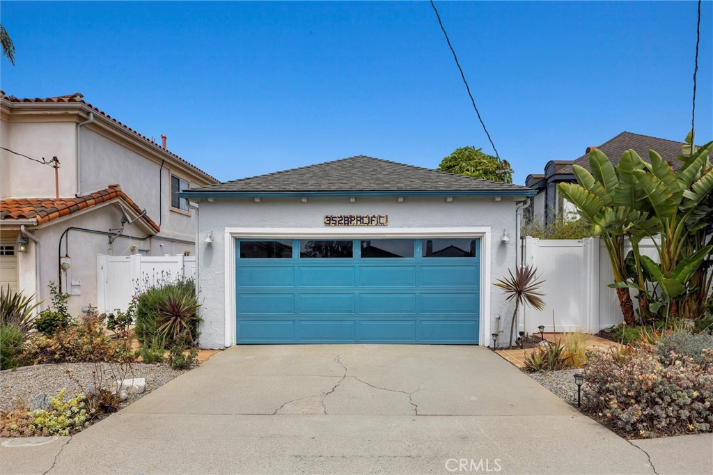 Coastal charm meets modern comfort in this light-filled 3 bed, 2.5 bath home nestled in the heart of the Tree Section of Manhattan Beach. Thoughtfully designed for both everyday living and relaxed entertaining, this home welcomes you with an airy living room featuring vaulted wood-beamed ceilings, rich hardwood floors, and a cozy wood burning fireplace, perfect for cool coastal evenings. The open-concept kitchen is a showstopper, bathed in natural light and accented by marble countertops, bar seating, a farmhouse sink, stainless steel appliances, a wine fridge, and a bold teal tile backsplash. A side door offers easy access to the private backyard, seamlessly connecting indoor and outdoor living. To the right, two generously sized bedrooms share a beautifully renovated full bathroom. To the left, you’ll find a convenient powder room, a dedicated laundry area with hookups, and the spacious primary suite. French doors open to the side patio, while the spa-like en-suite features a dual sink vanity, stylish tile flooring, and ample closet space. The backyard is an entertainer’s dream, complete with a custom putting green and room for al fresco dining or weekend BBQs. The home also includes an oversized 2-car garage, offering plenty of storage and space for beach gear, bikes, or a home gym setup. Located moments from award-winning schools, downtown shops and restaurants, and world-class surf, this home offers the best of beachside living.