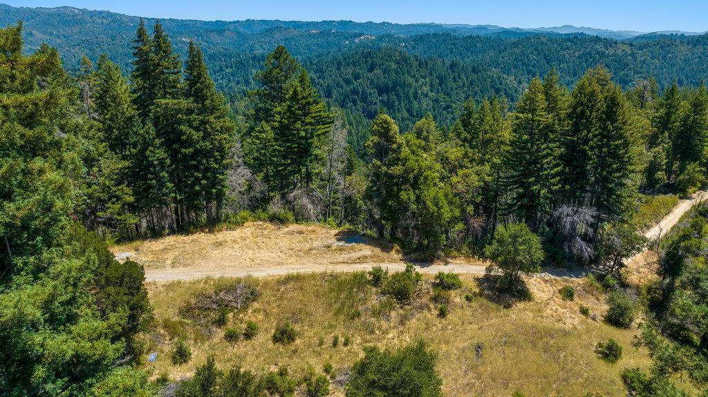 ONE OF A KIND! 40 acres of mountain ridges, large sloping meadows, forest and seasonal creeks. Multiple potential building sites with expansive panoramic canyon and mountain views, overlooking the San Lorenzo Valley. With plenty of sunshine, varied terrain, and total privacy, this is like owning your own state park, great for recreational living. Off-Grid solar system (13,860 watts) with battery banks (56kwh) supply two RV sites with full electrical, water and waste hookups - perfect for living on the property while you build dream home or summer retreat. There are two level-2 electric car charging stations there as well. A covered patio area serves as the solar structure and storage. 5000 gallon water tank is in place. The dirt/gravel driveway is gated and accessible from Tradewinds Drive, which is just above the Boulder Creek golf course off of Big Basin highway 236. 45 minutes to Silicon Valley. Timber Production zoning allows for timber harvesting, which can help fund your dream home and supply all the wood you need for building. County notice of violation is present and buyer to address.