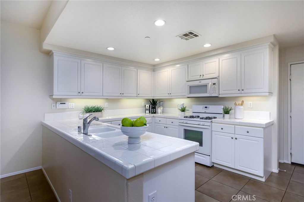 Spacious & Bright Move-In-Ready Townhome in Citrus Commons at The Preserve at Chino - Dual Primary Suites! And a 2-Car Attached Garage! Charming Solid Covered Front Porch Invites You Inside ... Approx 1,535 Square Foot Tri-Level Floorplan Features Two Bedrooms and Two Full & One Half Bathrooms - Open & Modern Main Level Great Room with Neutral Tile Flooring has Living & Dining Space - Large Chef’s Kitchen Boasts Ample White Cabinetry, White Tile Countertops, Recessed Lighting, Stainless Steel Dishwasher, Microwave & Gas Cooktop/Oven - Primary Suite on the 2nd Level has a Big Walk-In Closet and En-Suite Primary Bathroom with Shower with Seat - Convenient Upstairs Laundry Room with Built-In Cabinetry - Second Primary Suite on the 3rd Level with Cut-Out Office/Desk Area and an En-Suite Bathroom with Tub/Shower - Half Bath Powder Room on Main Level for Guests - Attached 2-Car Garage with Direct Access into the Home - Grassy Area for Pets & Numerous Parking Spaces for Guests Both Very Close By - $306/month Citrus Commons HOA Includes Exterior Maintenance of the Home (roof, paint, stucco, etc) and Landscaping - $62/month + $81/month The Preserve at Chino HOA - Life in The Preserve Includes Access to Three State-of-the-Art Recreation Centers (with a 4th center planned to open in 2026) Featuring Endless Amenities, Including Multiple Pools, Spas, Tennis Courts, BBQs, Library, Fitness Centers, Hobby & Craft Room, Movie Theatre, Tot Lots, Dog Parks, Pickleball & Basketball Courts, Community Garden, Event Rooms, Cabanas & More! Surrounded by Acres of Neighborhood Parks, Open Space & Walking Trails - Nearby Newly Opened Town Center at The Preserve has On-Site Shopping, Dining & Entertainment - Conveniently Located Near Award-Winning Schools, Cal Aero Preserve Academy (K-8), Legacy Academy (K-8) and Chino Hills High School - Just Minutes from El Prado Golf Course & Prado Regional Park, with Easy Access to the 71 & 91 Freeways