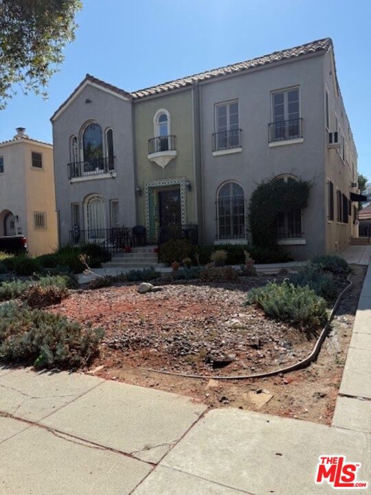 Spanish Stunner! Upper 2 beds & 1.50 baths. So many windows make this unit very bright and airy. Magnificent hardwood floors throughout most of the unit. Grand living room with faux fireplace next to lovely dining room. Updated kitchen with stove, dishwasher and refrigerator. Private back porch area has laundry hook ups. Back porch side entrance. Powder room in hallway. There are 2 wonderfully sized bedrooms with good closets. Updated full bath with tub/shower combo. One car parking on back area. Good location to fun cafe's and boutiques on LaBrea. Owner will consider small pet. Ask for rental criteria. Tenants must obtain and provide renters insurance if approved