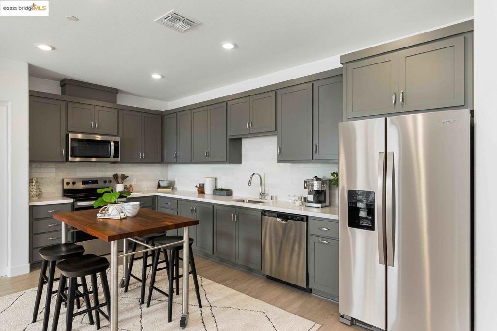 Single-Level Living in a New Construction Elevator Building! Unit 206 boasts a spacious 1,407 square feet of modern living, all conveniently located on one floor. This stunning 3-bedroom, 2-bathroom flat features a designer-inspired open floor plan that seamlessly blends the kitchen, living, and dining areas. The chef's kitchen is a dream, complete with ample counter space. Unwind your spacious private deck with views of Hayward. Unit 206 even features a side-by-side washer and dryer tucked away in a dedicated laundry room. The primary suite provides a tranquil oasis featuring a luxurious ensuite bathroom. This elevator building offers unparalleled convenience. The SoMi community will feature a dog park, overlook park, and a public walking trail within the community. Great location and a short walk to BART. Easy access to the 880 and 580 for commuters.