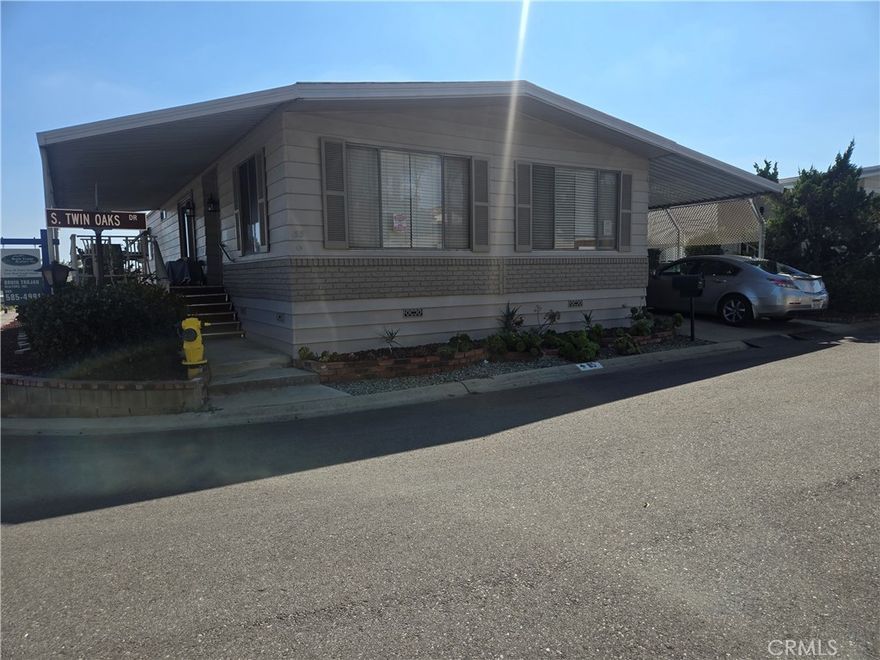 Just reduced 10K AND SOMETHING UNIQUE YOU SHOULD KNOW.  THIS SPACE HAS GUEST PARKING FOR 5 CARS. This mobile home is located in Twin Oaks Park on a corner knoll.  It is an extremely well-groomed park in La Verne, super convenient to the 210 freeway.  This well-cared-for coach was painted recently. There is a wheelchair lift in the carport, a covered deck/porch above the road grade, so you will always capture a friendly breeze. The floor plan is open and circulates well from the kitchen to the formal dining to the 2 living room spaces and bedrooms. The lot is landscaped, and recently the carport was reworked to be wider and new supports added ALONG WITH a lift for a wheel chair plus large storage shed. Laminent flooring was installed throughout in 2024.  Seller is moving into assisted living and apologizes for the crowded storage in the bedrooms and dining room.  Located only a short stroll from the clubhouse, residents can take advantage of an array of resort-inspired features, including a pool, spa, fitness center, billiards, card tables, and a versatile event hall. Twin Oaks offers a prime setting close to shopping, restaurants, medical services, major freeways, and public transportation—an excellent choice for those seeking an easy-care lifestyle in a friendly 55+ community. All showings must be by appointment and sale and possession are conditioned upon seller getting in to an assisted living facility.