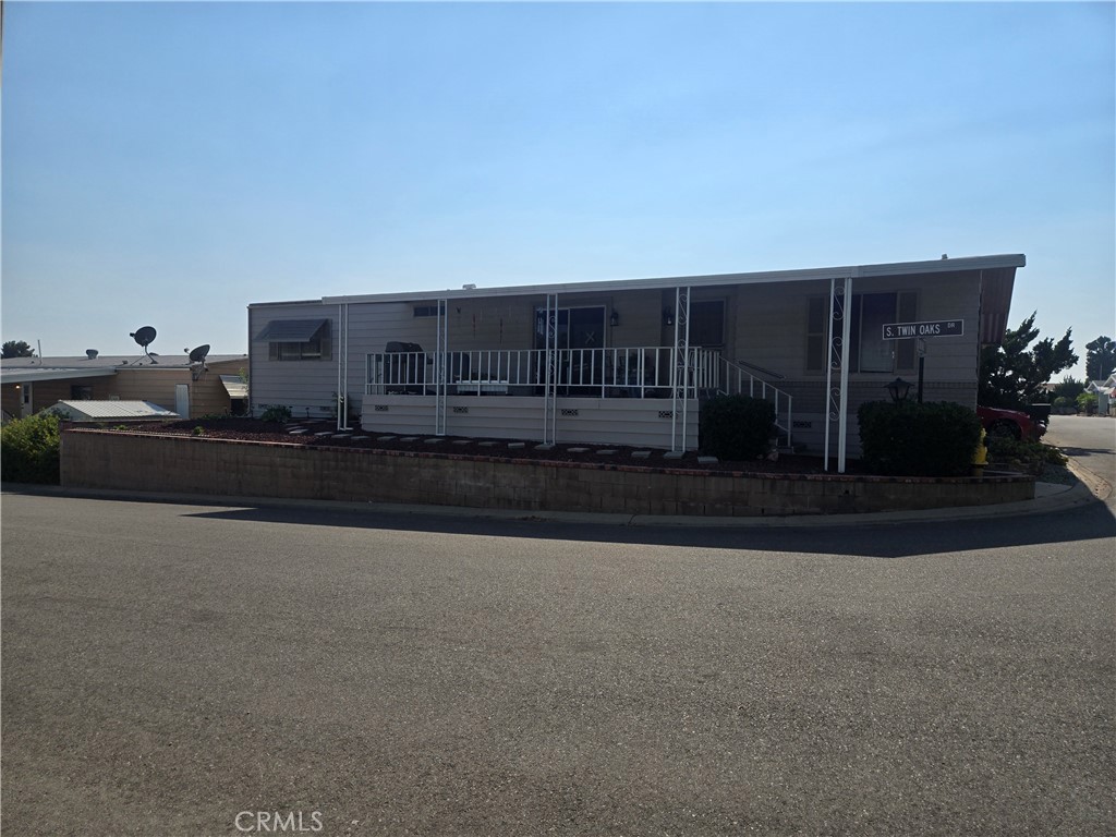 This mobile home is located in Twin Oaks Park on a corner knoll. It is an extremely well-groomed park in La Verne, super convenient to the 210 freeway. This well-cared-for coach was painted recently. There is a wheelchair lift in the carport, a covered deck/porch above the road grade, so you will always capture a friendly breeze. The floor plan is open and circulates well from the kitchen to the formal dining to the 2 living room spaces and bedrooms. The lot is landscaped, and recently the carport was reworked to be wider and new supports were added. Laminent flooring was installed throughout in 2024. Seller is moving into assisted living and apologizes for the crowded storage in the bedrooms and dining room. Located only a short stroll from the clubhouse, residents can take advantage of an array of resort-inspired features, including a pool, spa, fitness center, billiards, card tables, and a versatile event hall. Twin Oaks offers a prime setting close to shopping, restaurants, medical services, major freeways, and public transportation—an excellent choice for those seeking an easy-care lifestyle in a friendly 55+ community. All showings must be by appointment