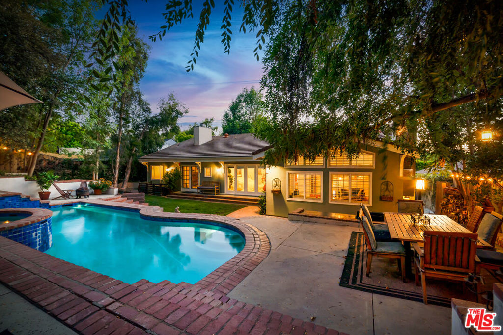 Now offered at a significantly reduced price, 5252 Vanalden Ave is an incredible value for this one-of-a-kind Tarzana retreat filled with charm, character, and endless possibilities. This stunning California Ranch-style home with a Spanish tile roof features 4 bedrooms, 3.5 bathrooms, and 2,768 sq ft of warm, welcoming living space on a sprawling 19,218 sq ft lot. Behind the gated front yard, you'll find a perfect grassy play area for kids and pets. Enter through the inviting front porchpast the peaceful fishpondand step into a dramatic great room with soaring cathedral ceilings and gleaming wood floors. The open kitchen and family room, complete with a fireplace and custom built-ins, create the heart of the home. Storage is abundant throughout, with closets and built-ins making organization a breeze. The spacious primary suite offers a fireplace, French doors to the pool and spa, walk-in closet, soaking tub, and oversized shower. A front guest bedroom has its own ensuite bath, while two additional bedrooms share a Jack-and-Jill. A bonus office nook near the kitchen is perfect for Zoom calls or creative projects. The entertainer's backyard features a built-in BBQ and fridge, a sparkling pool, and a hillside path leading to a magical, oversized treehouse strung with lightsideal for sleepovers, playdates, or stargazing. Thoughtful upgrades like a whole-house fan, solar attic fans, double insulation, and energy-efficient systems keep the home cool and comfortable. The finished garage provides even more flexible space for a studio or home office. This home is bursting with potential, comfort, and a little bit of magicall at a new, more accessible price. Don't miss your chance to make it yours!
