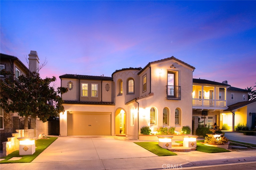 This turnkey estate, featuring distinguished Spanish architectural elements, is located within the prestigious Foxfield development of Vista del Verde. Model 2 offers a highly desirable floor plan with thoughtful upgrades that suit various lifestyles. The residence encompasses 3,920 square feet of living space, including four spacious bedrooms and two and a half bathrooms, as well as an attached ground-level in-law suite (5TH Bedroom) with a private bathroom and separate entrance for added versatility.
Upon entering the grand foyer, residents are welcomed by soaring vaulted ceilings and an open living room anchored by an arched gas fireplace with a pre-cast concrete mantel, surround, and hearth. Architectural highlights include dramatic ceilings, soffits, graceful arches, and a custom-crafted staircase with stained maple handrails and upgraded wrought iron balusters.
The home features a large interior laundry room equipped with a deep sink and custom storage cabinetry. The gourmet kitchen is designed with a center island overlooking the dining area, extensive custom storage, a walk-in pantry, a five-burner cooktop with vented hood, double oven, built-in refrigerator, microwave, and dishwasher. The elegant dining room, bathed in natural light, is ideal for entertaining.
Upstairs, the builder-option loft creates an inviting and flexible space suitable for a game room, office, study area, or home gym. The master suite includes a luxurious bathroom, private dressing area, walk-in closet, dual sinks, an oval soaking tub, and a separate walk-in shower. A walk-out balcony from the master bath provides impressive sunset and city light views.
The backyard is designed for entertaining, with drought-tolerant landscaping, concrete pathways, a rose garden, a covered patio with an island, and a stainless steel BBQ with an additional burner and sink. The exterior is enhanced by stone accents, ornamental wrought iron fixtures, wood shutters, and elegant arches.
The in-law suite stands out as a valuable amenity, offering private access, a spacious closet, a niche for a living area or office, and a full bathroom. This meticulously maintained home exudes charm and warmth, presenting an excellent opportunity for discerning buyers.