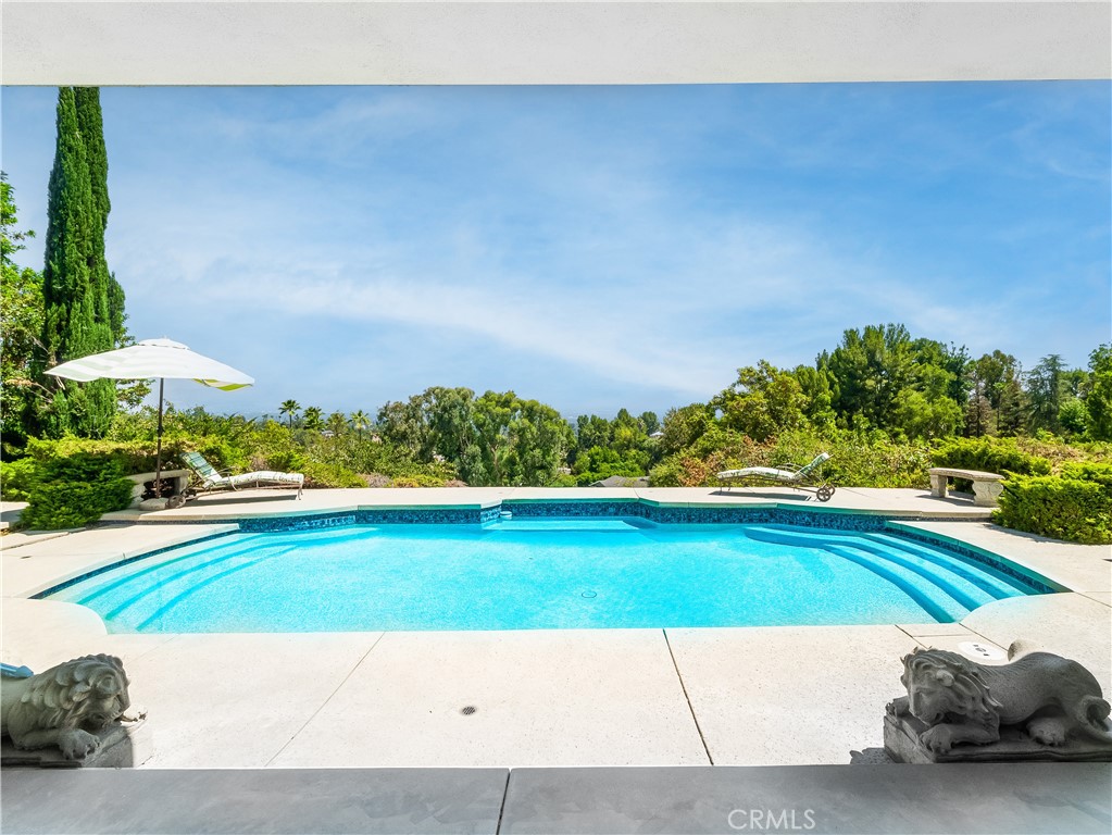 VIEW VIEW VIEW!!! Single story home with great curb appeal and circular driveway surrounded by mature pine trees. As you enter the first door to the property you are standing in a beautiful atrium. The next door leads you into the home with glass windows from ceiling to floor. The views are breathtaking. Once, you enter the private backyard you instantly feel like you are on vacation. The pool glistens in the sunlight. The home features a large master along with 2 large bedrooms. The formal living room is a great place to gather with friends by the fireplace. New carpet and paint. Lots of natural light throughout and walls of glass overlooking the backyard.