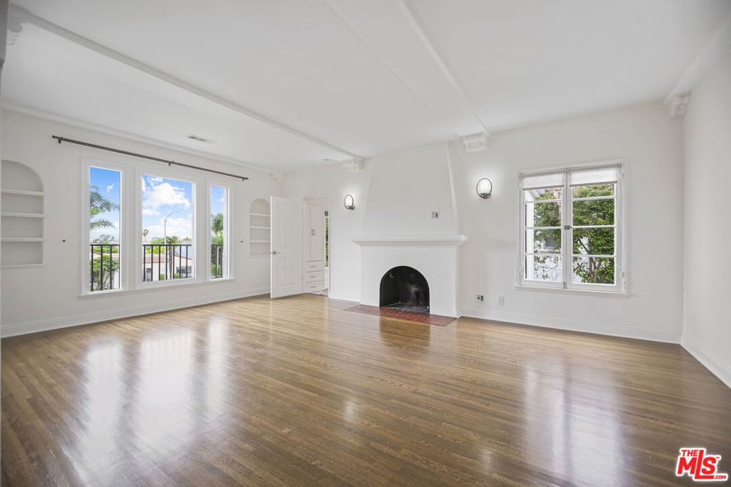 RENT SPECIAL: OWNER OFFERING 2 MONTHS FREE RENT. Elegantly and classically renovated upper unit with views in a Spanish style duplex on a beautiful street in Miracle Mile. Four spacious bedrooms combined with graciously sized living spaces, mountain and city views, and a designated yard create a special space that is uncommon to find in the rental market. Highlighted by hardwood floors, recently updated bathrooms, central HVAC, and in-unit washer and dryer, this unique residence seamlessly combines old-world charm with today's modern amenities. The massive chef's kitchen features stainless steel appliances, custom shaker cabinets and quartz countertops. The enormous primary suite includes a walk-in closet and an ensuite bathroom with dual vanity, Carrera marble countertops, and separate tub and shower. Situated moments from world-class destinations such as LACMA, The Grove, and The Beverly Center, this property offers both a serene retreat and access to the vibrant cultural and dining scene of Los Angeles.