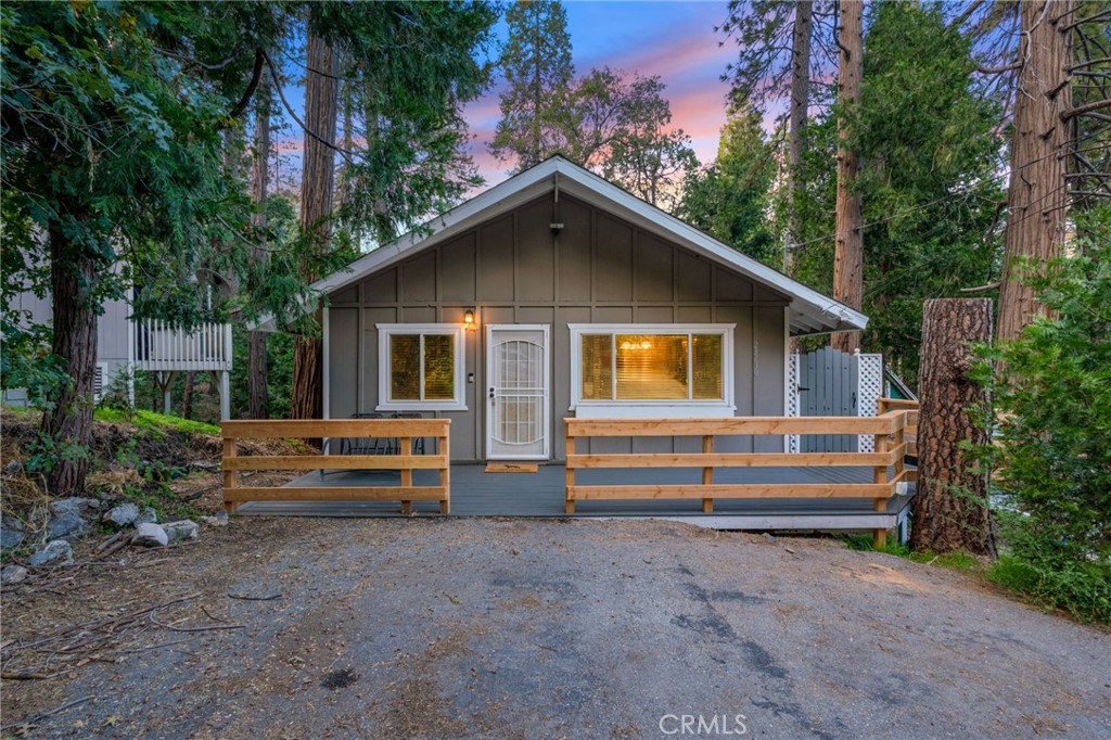 Exquisite single-family residence, blending the allure of a cabin with modern renovations! This home boasts 3 bedrooms (one on the main level and two on the lower level), along with a fully renovated bathroom on the main floor. The open layout showcases hardwood flooring and a cozy wood- burning fireplace. The interior has a fresh coat of paint, and the exterior displays all-wood finishing. The kitchen gleams with brand new cabinets, granite countertops, and state-of-the-art stainless steel appliances. This gem is a must-visit, perfectly situated close to a lake. Additional features include: Brand new water heater, Double-glazed windows from Anlin, complete with a transferable warranty, freshly installed deck featuring Trex waterproof decking. Enjoy a short stroll to the lake or neighboring stores. Relish the breathtaking views of the mountains and the stream. This home won't let you down!
