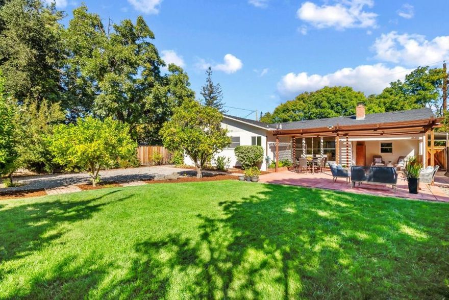 Set on a generous 10,125-square-foot lot, this inviting three-bedroom, two-bathroom Los Altos residence blends comfort, natural light, and thoughtful updates. Set back from the street and surrounded by lush green trees and bushes this single-level floor plan is enhanced by hardwood floors throughout, freshly painted interiors and exterior, and recessed lighting that creates a bright, welcoming atmosphere. Outdoors, the sun-drenched backyard provides a versatile canvas for living whether enjoying a quiet afternoon on the shaded patio nook, gathering for games on the open lawn, or cultivating citrus and fruit trees in the garden. The rear yard is currently accented by fig, orange, apple, plum and even a pumelo tree. The living and dining rooms extend effortlessly toward the outdoors, where a wall of windows captures leafy views of the expansive backyard.  With its warm character, versatile layout, and sun-drenched outdoor spaces, this residence offers an exceptional opportunity to enjoy Los Altos living at its best. Discover the perfect balance of comfort and style.   Just moments away are parks, shopping conveniences, El Camino Hospital, as well as Oak Elementary, Blach Middle and Mountain View High School (Buyer to verify attendance).