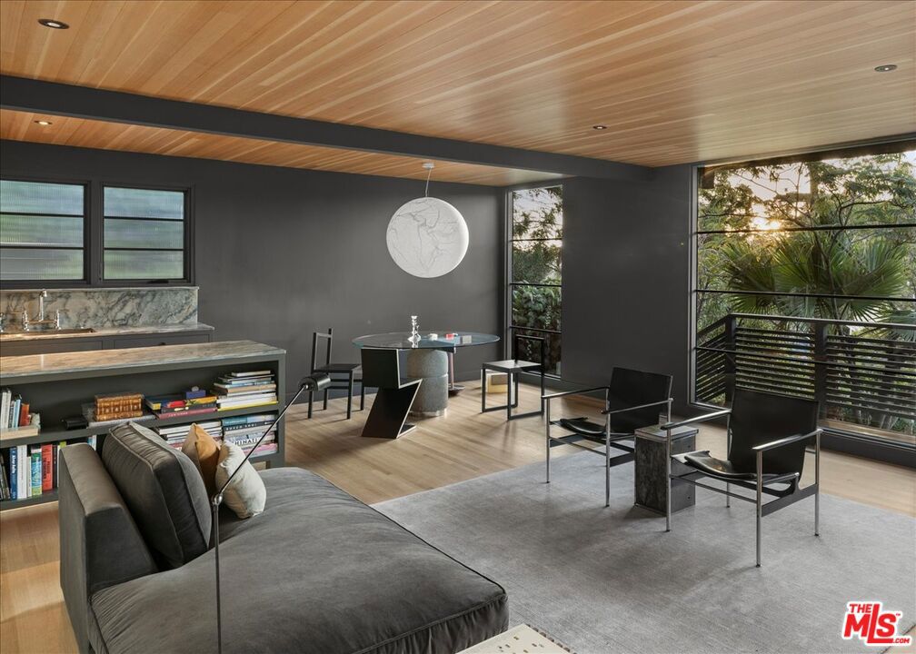 4934 La Roda Avenue is a fully reimagined mid-century home where no detail was overlooked. Every inch of this 3 bedroom, 2 bath residence has been meticulously renovated with the highest quality materials and a designer's eye for both beauty and function. The open living, dining, and kitchen spaces are grounded by solid white oak flooring and dramatic Douglas fir ceilings, creating a warm architectural backdrop. Natural light pours through, highlighting the craftsmanship and clean, modern lines throughout. At the heart of the home, the chef's kitchen is both refined and practical. Custom inset wood cabinetry, striking quartzite counters and backsplash, and a carefully selected suite of premium appliances include a Bosch dishwasher, Fisher & Paykel paneled refrigerator, and a professional grade Wolf gas range with pot filler and Zephyr hood. Every element was chosen for its quality and design impact. Both bathrooms are fully tiled and distinct in character. One is wrapped in bold green Zia tile with black marble floors. The other is finished in timeless Carrara marble. The primary suite includes a custom walk in closet with built ins, balancing luxury with everyday practicality. One of the additional bedrooms features a built in desk and a glass door that opens directly to the front patio, making it ideal for a home office or creative studio. Beyond the aesthetics, every system is brand new. HVAC, tankless water heater, laundry appliances, and even the custom wood garage door have all been newly installed. Outdoors, a Brazilian hardwood deck and fenced yard with mountain views extend the living space with the same attention to detail. Set on a 5,703 square foot lot in the heart of Eagle Rock, the home is just moments from the vibrant shops, cafes, and restaurants along Colorado Boulevard. This is not just a remodel. It is a complete reinvention, designed and built with uncompromising quality.
