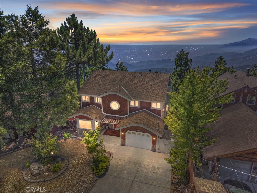 Experience breathtaking mountain, city lights and incredible sunset-views from this beautiful 2,625 sq' home set on a spacious 13,144 sq' forested lot. Located on a quiet street with no through traffic. ~ This level-entry residence features an oversized garage on a maintained & plowed road for easy access. ~ Built in 2000 and maintained in pristine condition, the home offers an open floor plan with soaring ceilings, 4 bedrooms, and 3.5 baths. ~ The outdoor living space with spa-tub and those magnificent views. ~ The main level boasts a luxurious master suite and a dedicated office space, perfect for work-from-home days. Upgraded kitchen with granite counters & custom cabinetry opens into dining area and from there out to the extra large deck to enjoy more of the outdoors. ~ Additional highlights include a separate guest studio that is currently rented for $800/month (or could be workshop, gym, or ??) and a versatile loft/family room for relaxation and entertaining. ~ Enjoy the convenience & comfort of A/C, Dual Pane windows, 40-year roof plus public utilities and high-speed internet and house is already set and wired for your generator. ~ For your convenience and instant enjoyment, we are offering this home mostly furnished and decorated (per sellers inventory list) ~ All of this in a peaceful, natural setting. This move-in-ready home combines stunning vistas with comfort and functionality—your dream mountain retreat awaits!