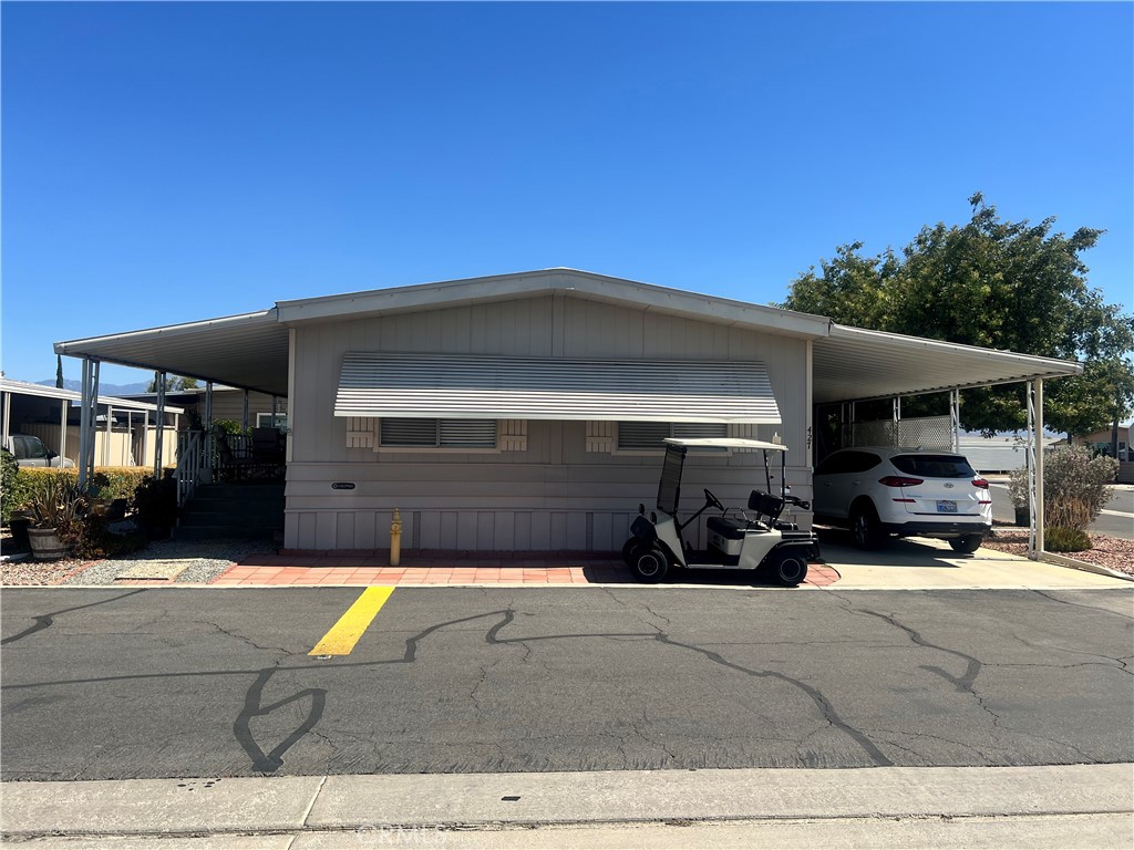 If you're looking for a home within a community that has plenty of nature, activities, and amenities then this may be the home and lifestyle that you're searching for. This well taken care of corner lot home has a large shady porch and lower patio area with plenty of space to relax or entertain. As you walk in you'll find a welcoming living room with 3 large windows providing plenty of natural light to both the living and dining area. Dining room area comes with a large built in curio and plenty of space for a nice size dining room. The kitchen is very well equipped many storage options, a dual door oven/broiler, 2 dual side pantry cabinet areas and window view sink area. Adjacent to and opening from kitchen is the Family/TV room with beautiful dark flooring and a double slider leading out to the large porch. For all who love to have a separate office/project/craft room are you'll appreciate the large room in the laundry area with all of it's additional built in cabinets on both sides of the wall. You will definitely not have to convert your guest room into an office with this option. Nicely sized primary bedroom with wall closet, primary bathroom with garden tub and walk in shower. Secondary bedroom with wall closet and an adjacent 2nd bathroom with walk in shower. Second bathroom is also accessible from the office/laundry area without having to go through a bedroom. Nice size carport with a shed and since it's a corner lot, you'll find no neighbors on the one side and shaded by a nice tree. Home comes with both Central AC/Heat and Swamp cooler, plenty of shade options with awning and carport covers.