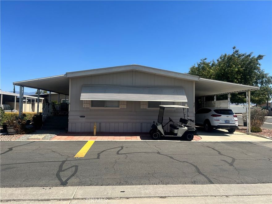 If you're looking for a home within a community that has plenty of nature, activities, and amenities then this may be the home and lifestyle that you're looking for. This well taken care of corner lot home has a large shady porch and lower patio area with plenty of space to relax or entertain. As you walk in you'll find a welcoming living room and dining area with 3 large windows providing plenty of natural light. Dining room area comes with a large built in curio and plenty of space for a nice size dining table. The kitchen is very well equipped with many storage options, a dual door oven/broiler, 2 dual side pantry cabinet areas and window view sink area. Adjacent to the kitchen is the Family/TV room with beautiful dark flooring and a double slider leading out to the large porch. For all who love to have a separate office/project/craft room area you'll appreciate the large room in the laundry/office area with all of the built in cabinets on both sides of the wall. You will definitely not have to convert your guest room into an office with this option. The  primary bedroom is nicely sized and has a wall closet with it's own primary bathroom with garden tub and walk in shower. Secondary bedroom also has a wall closet and an adjacent 2nd bathroom with walk in shower. Second bathroom is also accessible from the office/laundry area. Nice size carport with a shed. Since it's a corner lot home, you'll find no neighbors on the one side and shaded by a nice tree. Home comes with both Central AC/Heat and Swamp cooler, plenty of shade options with awning and carport covers. Come and see this home and tour the community.