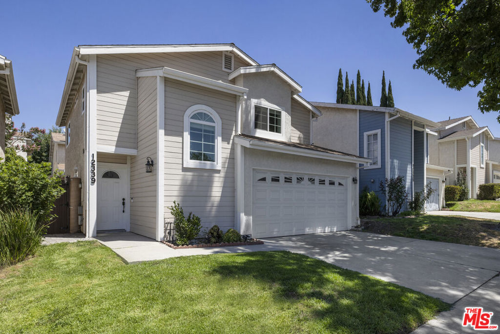 Welcome home to this stunning 3-bedroom, 3-bath residence offering 1,901 sq. ft. of beautifully designed living space! As you pass the manicured front yard and step through the covered entry, you're greeted by a spacious open-concept layout that seamlessly connects the living room, dining area, and kitchen. Light pours in from every angle, highlighting the decorative fireplace, crown molding, rich wood-like floors, wainscoting, and striking wood beam ceilings. The kitchen is a showstopper, featuring gorgeous granite countertops, custom cabinetry, a tumbled tile backsplash, and sleek stainless steel appliances. A stylish half bath and a large hallway closet complete the downstairs. Upstairs, you'll find an expansive primary suite with generous closet space and a full en-suite bath with granite counters. Two additional well-sized bedrooms offer versatility, including one with a built-in desk perfect for a home office setup. Another full bath with wainscoting and granite finishes adds to the home's charm and functionality. Enjoy your morning coffee or evening glass of wine in the peaceful privacy of your own yard. The attached 2-car garage features an insulated door and a separate laundry area. Located in a 24-hour gated community with access to a pool and spa, and just minutes from the 210 and 5 freeway. This is the one you've been waiting for!