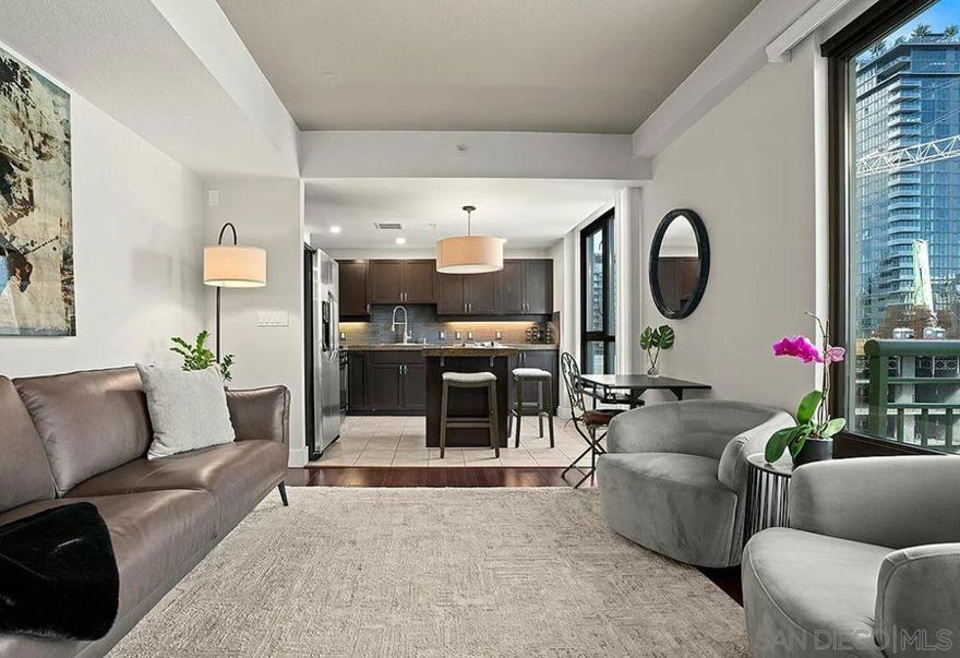 This well-maintained, FULLY FURNISHED unit offers a bright, open floor plan with large windows that bring in abundant natural light and showcase city views. The living and dining areas flow seamlessly, creating a comfortable and functional space for both relaxing and entertaining.  The kitchen is equipped with modern cabinetry, ample counter space, and quality appliances, making it easy to cook and host. The bedroom is generously sized with good closet space, and the bathroom features clean, contemporary finishes. In-unit laundry and thoughtful storage add to the unit's everyday convenience.  Treo is a well-managed community with amenities including a fitness center, resident lounge, secure entry, and parking. Located just steps from Little Italy's popular restaurants, cafés, farmers' market, and the waterfront, this unit offers an unbeatable downtown lifestyle.  Move-in ready and available now.