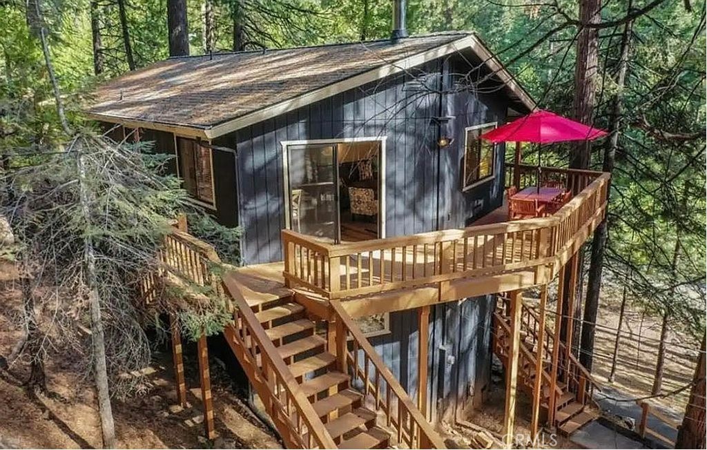 This beautiful, fully remodeled 4 bedroom cabin in the woods is ready for you to move into! Cabin also has a successful history with use for short term rentals. Upon entry, you'll discover the fresh feel throughout. Downstairs offers 2 bedrooms, a sitting room and full bathroom, along with ample storage. Upstairs in the main living area, discover a newly remodeled kitchen and an open floor plan which gives space for the dining area and living room where family can gather around the Lopi Evergreen wood burning stove. Both upstairs bedrooms are updated, along with a recently updated washer, dryer and water heater. Upstairs features a full bathroom. Wall heaters are present in every room to keep the cabin cozy. Outside you will find a wrap around porch, large storage shed, pull through driveway and EV charger. This adorable cabin is fully furnished and in turnkey condition!