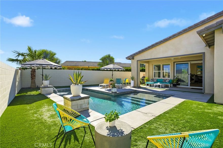 Welcome to 74376 Zeppelin Dr. in Genesis — a 2018-built, single-level showpiece with a crisp, mid-century–inspired aesthetic and the effortless livability of modern construction. Meticulously cared for, it presents like a nearly new build, with the added advantage of mature landscaping and a fully finished, move-in-ready setting so you can immediately enjoy the lifestyle.

Inside, the home is bright, clean, and elevated—an airy open-concept layout is amplified by 10-foot ceilings and walls of natural light. The designer kitchen is equal parts function and style, featuring a quartz waterfall-style island with seating, stainless appliances, subway tile backsplash, and under-cabinet lighting—perfect for both everyday living and effortless entertaining.

The primary suite is a calm retreat with backyard access, UBLOCKOUT motorized blackout shades for true total darkness, and a generous custom closet. The spa-inspired bath features a walk-in shower, oversized soaking tub with quartz surround, and a dual quartz vanity. Two additional bedrooms each offer en-suite baths, plus a dedicated office/den, three full baths + a powder room, and smart storage throughout (including a hall closet perfect for luggage or seasonal items).

A rare standout: the third-car garage, plus finished garages with epoxy flooring. High-value upgrades include 30 owned solar panels, a Tesla Powerwall, two EV chargers (NACS + J1772), a Nest wireless security system, and a Lutron Caséta lighting system, along with a tankless water heater, A/C, and ceiling fans.

Step outside and it becomes unforgettable: a private, resort-modern backyard with a saltwater pool featuring a tanning shelf, waterfalls, and Pentair ScreenLogic WiFi + Intellibrite color lighting—all controlled from your phone. There's low-maintenance artificial turf, with plenty of room for games and pets. And then there are the views: breathtaking mountain panoramas stretching to the Coachella Preserve and Joshua Tree National Park. In Genesis, homes that capture these big, wide-open sightlines are the true crown jewels—a daily backdrop that never gets old.

Genesis is a beautifully maintained gated community with a pool, spa, fitness center, walking paths, and security gates—and the low HOA is a standout value, including 1G fiber internet and DirecTV streaming. This is modern desert living at its best: design-forward, impeccably maintained, and framed by views that define the destination.