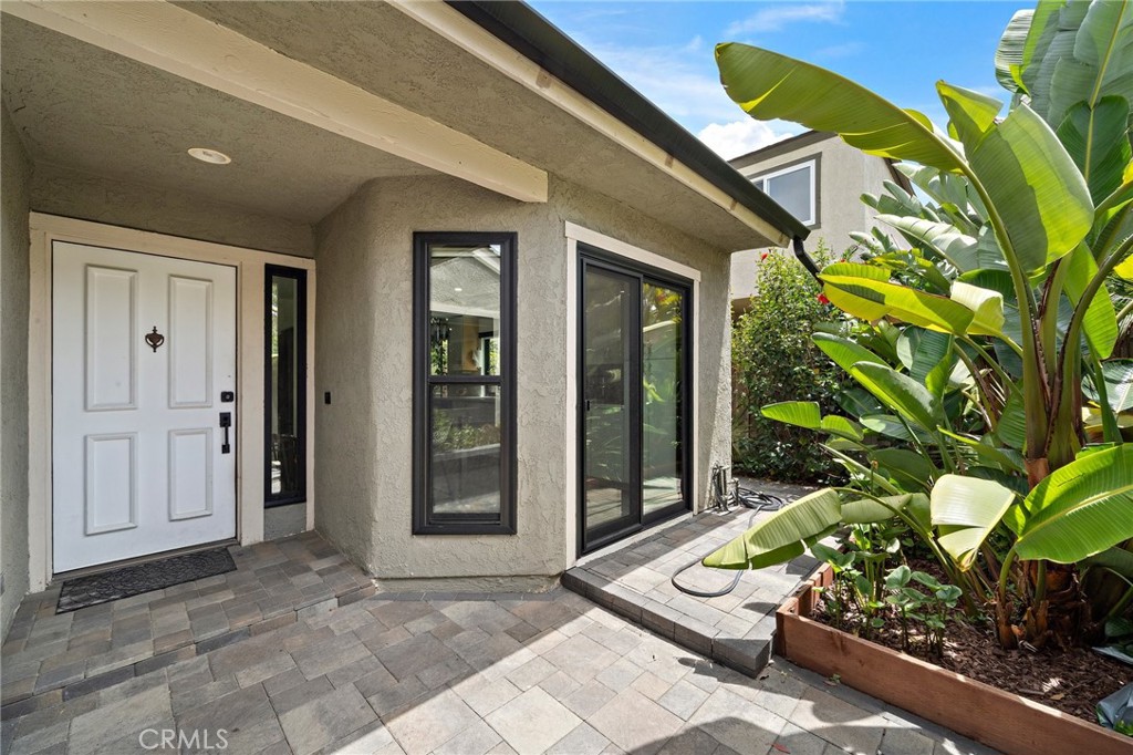 Investors dream! Tenant's lease is though June 13, 2026. Excellent tenant. Spacious two bedroom, single level condo with attached 2 car garage. This jewel has a private gated patio, upgraded: kitchen, bathrooms, floors, high end appliances, Fridge/ Washer & Dryer included. The best features are the tall ceilings, private patio and backyard. Wrap around yard with built in fire pit in backyard creates a nice ambiance for entertaining. Only minutes to the beach, shops, freeway and schools. Great location! Everything is easy to get to. Plus, this unit also has two car driveway! Guest parking is right beside home. Come and see this special get away, it's pleasantly surprising. The primary bedroom also features access to the patio, high ceilings, two large mirrored closets, custom shower and the secondary bedroom is side opposite the hallway. Only one shared wall and no one above you. No carpeting, all laminate flooring throughout. All walls have been painted white since pictures were taken. Includes a community pool, spa and clubhouse.