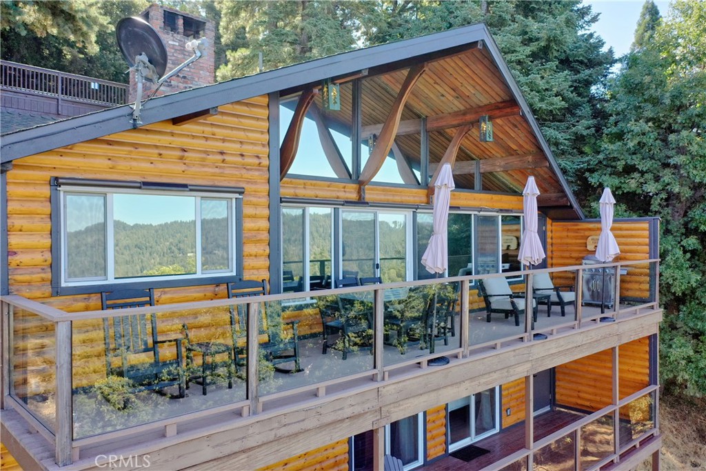 Experience the “Schoner Blick”(Beautiful View) of 816 Chamois. Arguably the best panoramic view of Lake Gregory, Mt. Baldy, Crestline basin and high desert the San Bernardino Mountain range has to offer! If you are dreaming of a quintessential upgraded mountain cabin, dream no further! This property exemplifies everything you’d imagine in a mountain getaway. This is a package deal offered turnkey furnished and INCLUDES the adjacent lake view vacant parcel(12,906 sq ft), for a total ½ acre of the nature’s utmost serenity. Upon entry of this 3 bedroom/2.5 bathroom retreat, you are greeted with an A frame North West facing wall of glass accentuating amazing unobstructed views. Entertain family & friends on a large upper Trex deck, the perfect party perch to enjoy July 4th fireworks over Lake Gregory. The entire interior is encased with knotty pine tongue and groove paneling. The exterior is wrapped in high quality log plank siding. Open concept main living area offers a soaring floor to ceiling brick fireplace, indoor BBQ chimney, and vinyl wood flooring throughout. The entry level master bedroom & lower level den also include their own fireplaces, for a total of 3 fireplaces. Every nook and cranny of this cabin is appropriately used for ample storage top to bottom. Since the sellers acquired the property in 2024, they put the icing on the cake through: new furnishings and decor, new tile flooring in bathrooms, created a level kiddo play area, cut a nature trail through vacant included parcel, new lighting & plumbing fixtures, 30 amp sub panel, added a pool table in garage/gaming area and installed a soothing sauna on the lower rear deck. Additional upgrades completed by prior owner included: a composition roof, tankless hot water heater, HVAC system with A/C, Generac natural gas whole house generator, stainless kitchen appliances, Trex decking w/ glass railing, remodeled bathrooms and kitchen, added the 2 car garage & parking deck, interior/exterior siding, vinyl dual pane sliders and windows, custom solar shades + tint for wall of glass. Ample parking in driveway plus a parking deck over the garage. No cross through traffic here, located at the end of a quite San Bernardino County paved and maintained road. This stunning property is a licensed short term rental with 38 recent 5 star reviews on Airbnb. Treat yourself to the tranquil setting and breathtaking view you deserve, tour Schoner Blick today!