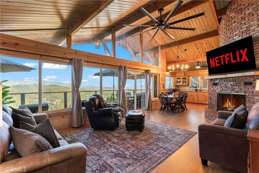 Experience the “Schoner Blick”(Beautiful View) of 816 Chamois. Arguably the best panoramic view of Lake Gregory, Mt. Baldy, Crestline basin and high desert the San Bernardino Mountain range has to offer! If you are dreaming of a quintessential upgraded mountain cabin, dream no further! This property exemplifies everything you’d imagine in a mountain getaway. This is a package deal offered turnkey furnished and INCLUDES the adjacent lake view vacant parcel(12,906 sq ft), for a total ½ acre of the nature’s utmost serenity. Upon entry of this 3 bedroom/2.5 bathroom retreat, you are greeted with an A frame North West facing wall of glass accentuating amazing unobstructed views. Entertain family & friends on a large upper Trex deck, the perfect party perch to enjoy July 4th fireworks over Lake Gregory. The entire interior is encased with knotty pine tongue and groove paneling. The exterior is wrapped in high quality log plank siding. Open concept main living area offers a soaring floor to ceiling brick fireplace, indoor BBQ chimney, and vinyl wood flooring throughout. The entry level master bedroom & lower level den also include their own fireplaces, for a total of 3 fireplaces. Every nook and cranny of this cabin is appropriately used for ample storage top to bottom. Since the sellers acquired the property in 2024, they put the icing on the cake through: new furnishings and decor, new tile flooring in bathrooms, created a level kiddo play area, cut a nature trail through vacant included parcel, new lighting & plumbing fixtures, 30 amp sub panel, added a pool table in garage/gaming area and installed a soothing sauna on the lower rear deck. Additional upgrades completed by prior owner included: a composition roof, tankless hot water heater, HVAC system with A/C, Generac natural gas whole house generator, stainless kitchen appliances, Trex decking w/ glass railing, remodeled bathrooms and kitchen, added the 2 car garage & parking deck, interior/exterior siding, vinyl dual pane sliders and windows, custom solar shades + tint for wall of glass. Ample parking in driveway plus a parking deck over the garage. No cross through traffic here, located at the end of a quite San Bernardino County paved and maintained road. This stunning property is a licensed short term rental with 38 recent 5 star reviews on Airbnb. Treat yourself to the tranquil setting and breathtaking view you deserve, tour Schoner Blick today!