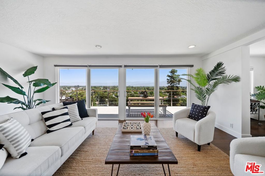 South of the Blvd, nestled in the hills of Studio City, this modern 3-bedroom, 3-bath sanctuary offers sweeping, unobstructed views of the valley and the glittering skyline beyond. As you descend the stairs to the main level, you are immediately embraced by privacy, space, and a sense of calm, wrapped in a canopy of mature trees that frame this hillside escape. The heart of the home unfolds in a spacious living room adorned with a cozy fireplace and an adjacent dining nook, perfect for intimate dinners or relaxed evenings with a view. Expansive sliding glass doors lead directly to a sprawling entertainment deck, a true showpiece for al fresco living. Watch the city lights shimmer beneath you as you sip wine under the stars or host vibrant gatherings that stretch long into the night. The updated kitchen is both functional and full of charm, featuring a gas stove, breakfast bar, and a whimsical swinging door that leads directly to a secluded patio designed for cool summer night dinners and fireside conversations. The master suite is a peaceful retreat with a private study, while the guest bedroom offers direct access to the deck and its breathtaking vistas. Descend once more to discover a jewel of this property. The 556 sq ft private guesthouse with a full kitchen, bath, living area, and bedroom. Whether used for visiting guests, a creative workspace, or your own personal haven, this lower-level suite offers both flexibility and seclusion. Lush landscaping and mature trees envelop the property, providing shade, serenity, and a rare sense of true privacy just minutes from the heart of the city. If you're seeking panoramic views, spacious indoor-outdoor living, and the luxury of your own hillside retreat, 11689 Picturesque Drive is a rare offering you won't want to miss. A short walk from the best bars, eateries and stores that Ventura Blvd has to offer in close proximity to some of the best public and private schools in LA.