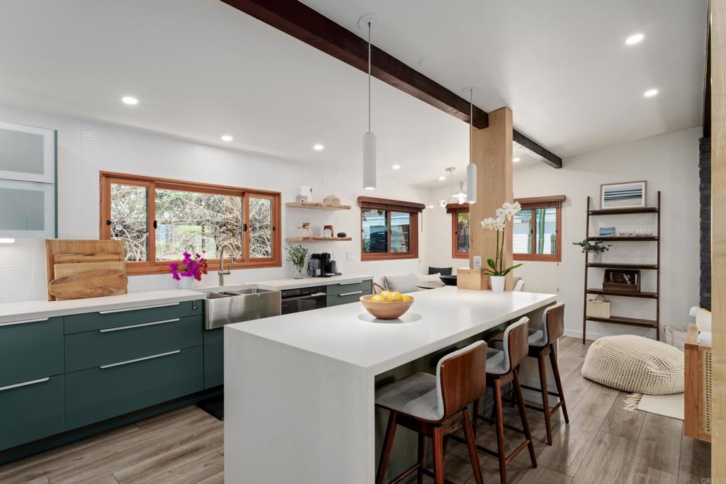Ideally situated across from the ocean on coveted Neptune Avenue in Leucadia, this fully remodeled coastal cottage offers the perfect mix of charm, privacy, and walkability. Just steps from Beacon's Beach and a short stroll to local shops and restaurants, it’s nestled in one of North County’s most desirable beachside neighborhoods. The main residence features a beautifully updated kitchen and bathrooms, along with newer windows, roof, flooring, electrical, and plumbing systems. A generous laundry/utility room adds practical convenience. Set on an extra-deep lot, the property offers spacious, usable front and back yards, along with a rare, extra-wide driveway providing off-street parking for up to three vehicles. At the rear of the property is a thoughtfully designed and just completed contemporary 1-bedroom, 1.5-bath ADU offering a modern, practical kitchen, generous loft bonus space, separate address, and easy side access—ideal for guests, rental income, or multigenerational living. This is a rare opportunity to own a versatile, move-in-ready coastal property in the heart of Encinitas.