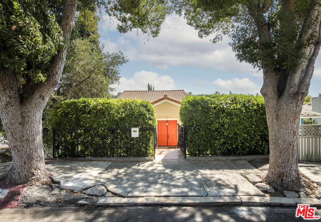 Perched high in the coveted hills of Eagle Rock, this sophisticated tri-level residence delivers privacy, drama, and sweeping skyline views. A drought-tolerant front garden leads to a shaded double-door entry, opening to soaring ceilings and a sun-drenched living room with built-ins and powder room. The newly reimagined kitchen dazzles with quartz counters, a generous island, and top-tier stainless appliances, flowing seamlessly to the dining area and expansive balcony for al fresco evenings with the city lights as your backdrop.Upstairs, the primary suite is a true retreat with its own balcony, walk-in closet, and spa-style bath featuring dual sinks, soaking tub, and glass-enclosed shower. A versatile bonus room nearby is ideal as a nursery or office. The lower level offers two additional bedrooms, a sleekly remodeled bath, and a spacious bonus room ready for a home gym, media lounge, or creative studio.Out back, an entertainer's playground awaits a sparkling pool with cabana, shaded terrace, and a lush collection of fruit trees. Multiple balconies capture the magic of indoor-outdoor California living. Just moments to Eagle Rock's prized schools, Trader Joe's, trendy cafes, and parks, this turnkey home embodies style, serenity, and location all in one.